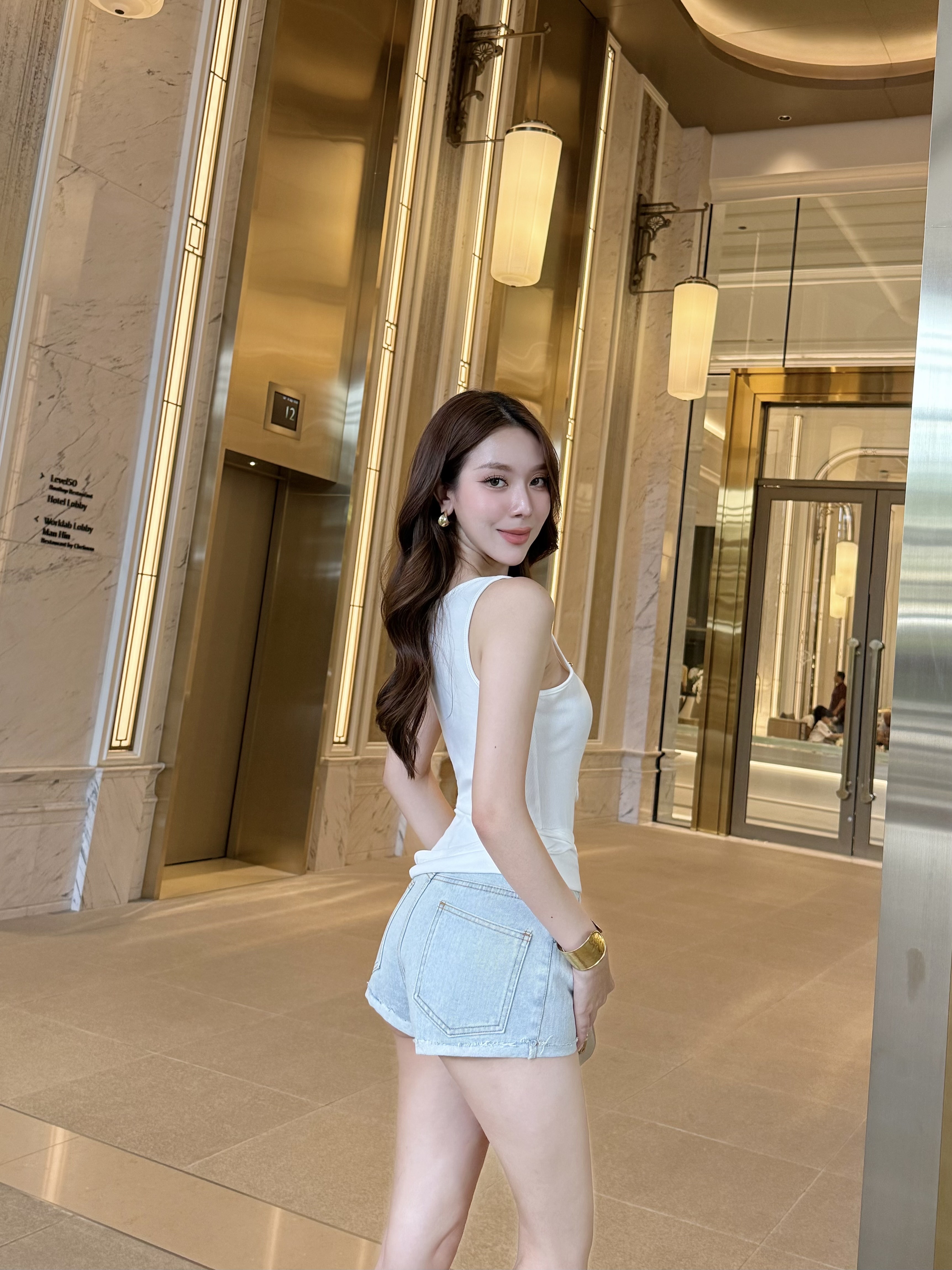 Set เสื้อสายเดี่ยวสีขาวดีไซน์คอเว้าลึกทรงโค้ง เพิ่มความแซ่บแบบพอดี เนื้อผ้ายืดกระชับ เก็บทรงแนบตัว ใส่แล้วหุ่นสวยเป๊ะแมทช์ง่าย มากับกางเกงยีนส์สีอ่อนขาสั้นพับขา เรียบแต่เผ็ช! ลุคนี้เหมาะกับสายคาเฟ่ สายชิล หรือจะแต่งออกงานก็เปรี้ยวลงตัว