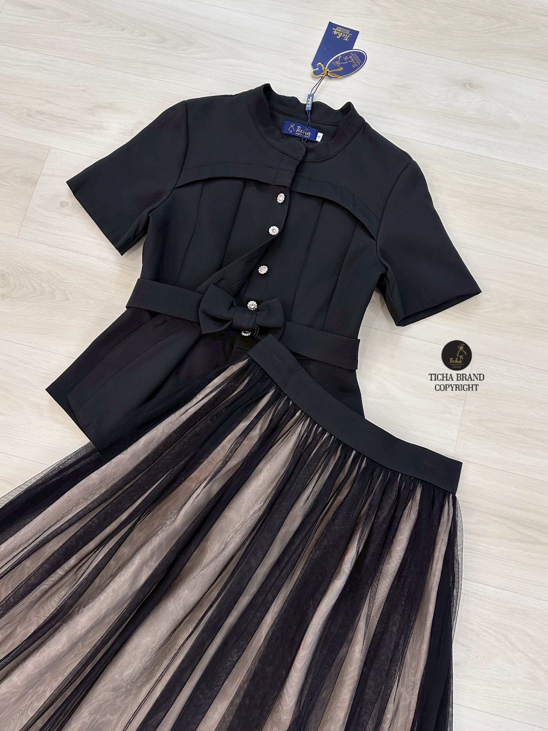 Set 2 ชิ้น สีดำเสื้อเบเซอร์คอจีนแขน ด้านหน้าดีเทลตีเกร็ตโค้งสวย และแต่งกระดุมดอกไม้เพชรเรียงยาวใช้งานได้จริงมาพร้อมเข็มขัดโบว์มรกระดุมแป๊ก มาคู่กับกระโปรงยาว แต่งผ้ามุ้งตาข่ายคลุมด้านนอกสีดำ มีชับในสีครีม(ซิปหลัง) งานสวย เนื้อผ้าดี คัตติ๊งเป๊ะคะ