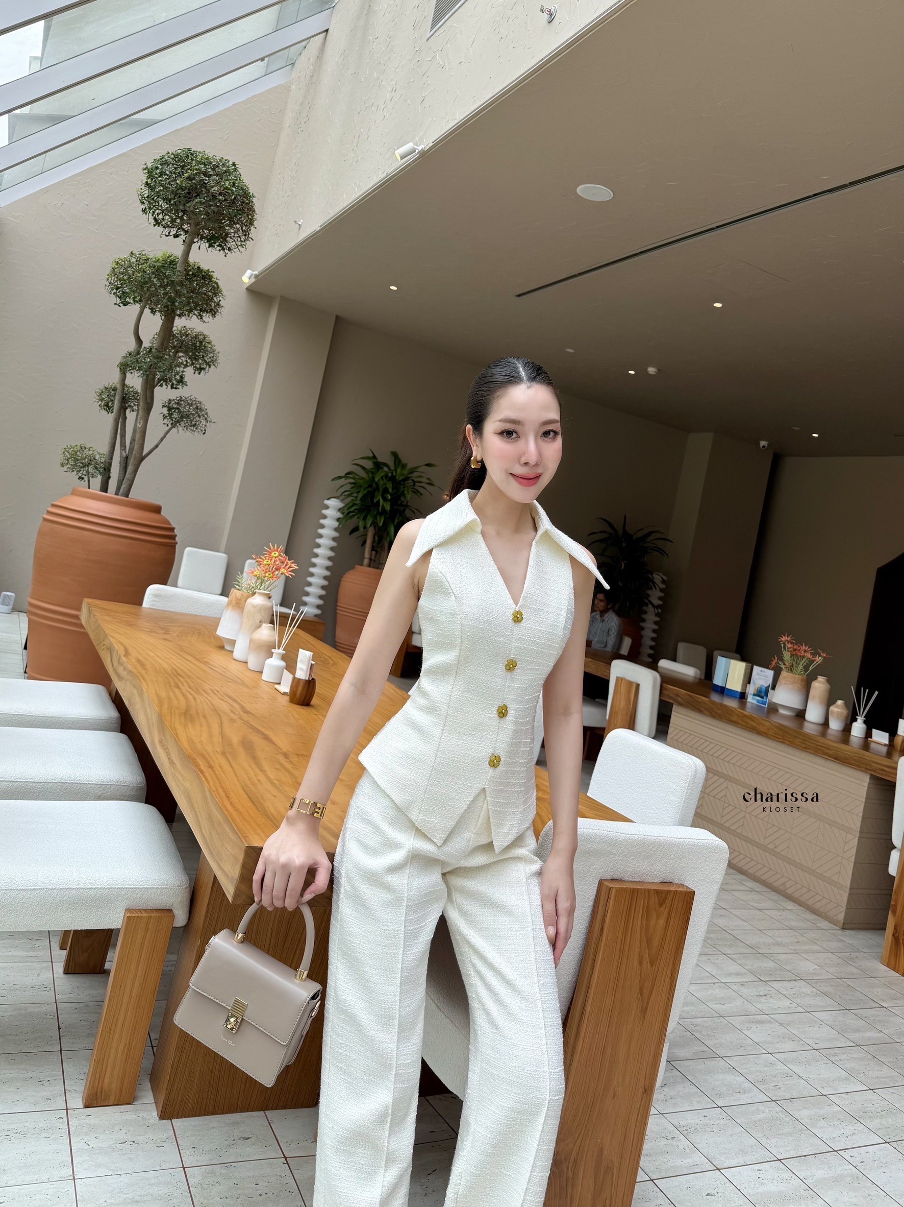 ชุดเซ็ทเสื้อแขนกุดทรงเข้ารูปแต่งกระดุมดอกไม้ เพิ่มความโดดเด่นด้วยการดีไซน์ให้ปกดูใหญ่ทำให้ดูผอม มีซับในทั้งตัว ซับในเป็นผ้าซิน เสื้อเป็นซิปด้านหลังมาพร้อมกับกางเกงใช้ผ้าเดียวกันกับเสื้อ ซิปตะขอด้านหน้า กระเป๋าจริง มีซับในเป็นผ้าซาตินอย่างดี