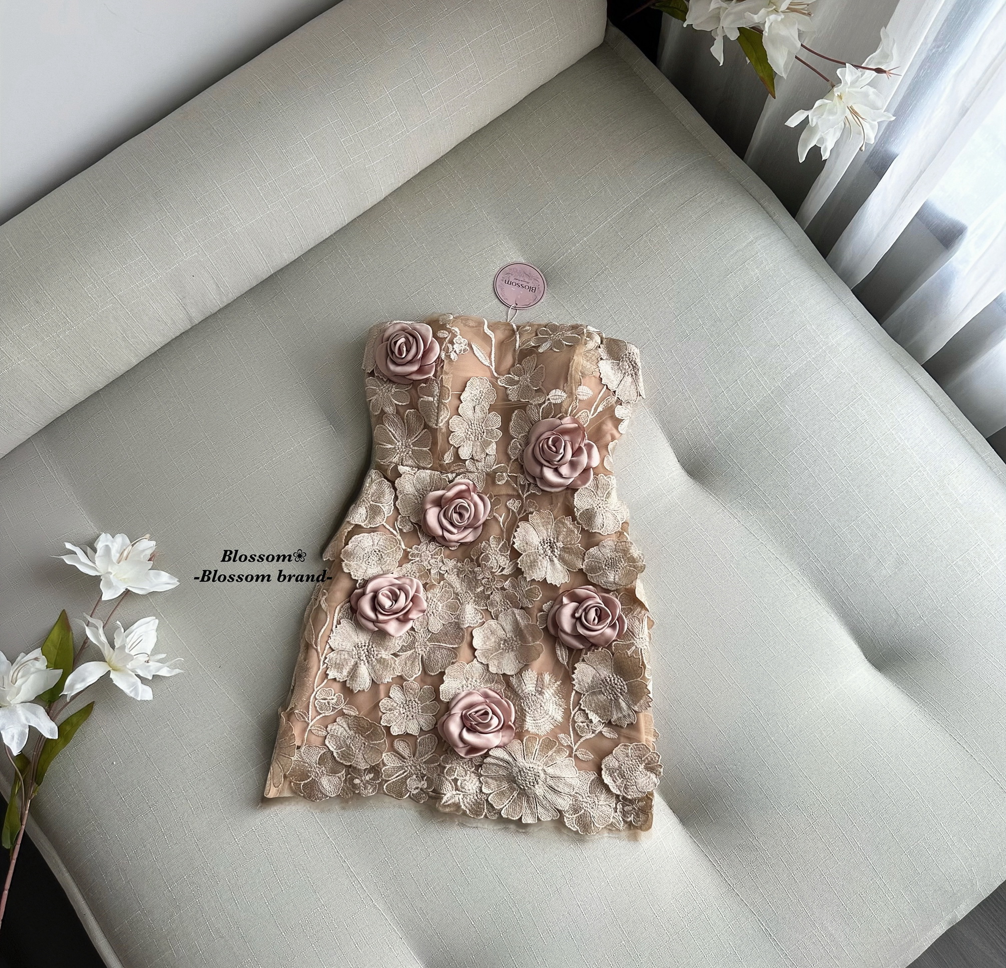 เดรสสั้นเกาะอก ออกแบบในสไตล์หรูหราเฉพาะตัว โดดเด่นด้วยงาน ปักลายดอกไม้และลูกไม้ 3 มิติ ทั้งตัว ให้เลเยอร์สวยเด่นแบบงานพรีเมียม ใส่แล้วช่วยขับผิวและทำให้ลุคดูแพง ช่วงหน้าอกมีฟองน้ำในตัว