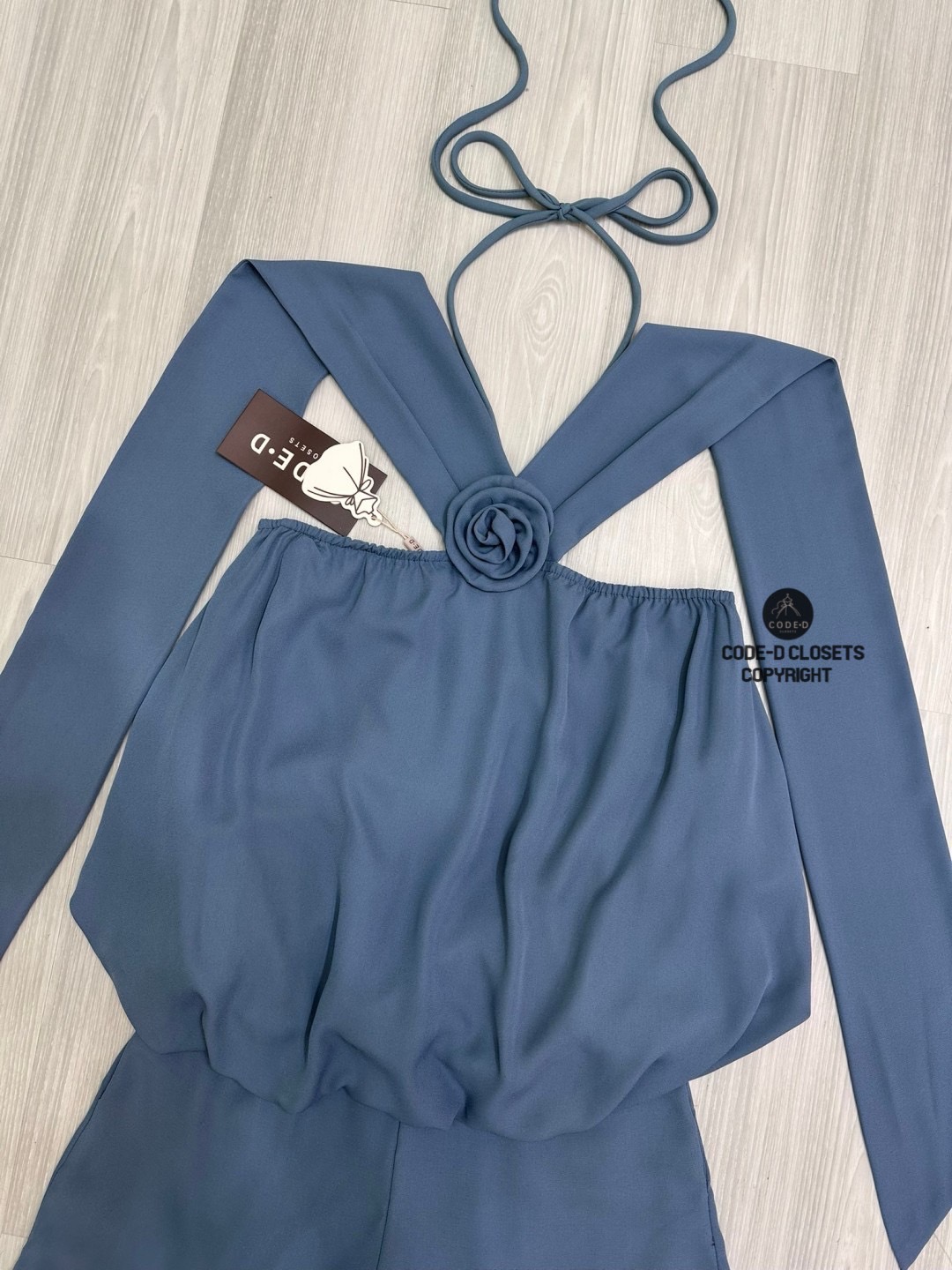 Set 2 ชิ้นสีครามผ้าชีฟองเนี้อทราย ตัวเสื้อแขนกุดสายคล้องคอผูกโบว์และสายคาดไหล่ระบาย อกแต่งอะไหล่เข็มกลัดดอกไม้ ตัวเสื้อจับจีบคลาย ๆ ทรงทวย ตัวเสื้อเป็นทรงฟักทอง (สม็อคจั้มเอว)ดีไซน์เว้าหลัง สวมใส่ง่าย มาพร้อมกับกางเกงขาสั้น (ซิปหลัง) เนื้อผ้าชีฟองนี้ทรายอ