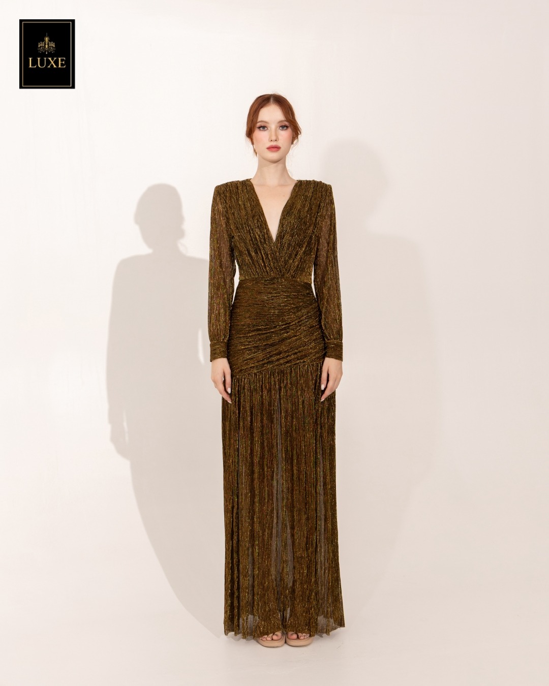 Label : LUXE แม็กซี่เดรสเสื้อคอวีป้าย แขนยาวเสริมไหล่ กระโปรงจับเดรปย่นเข้ารูปตรงสะโพก ต่อชายกระโปรงบาน ผ่าหน้าขา ทำจากผ้าราเม่อัดพลีทผสมดิ้นเมทัลลิก ผ้านุ่ม ยืดหยุ่น ใส่สบาย เล่นแสงสวย มีซิปซ่อนและซับในเต็มตัวค่ะ