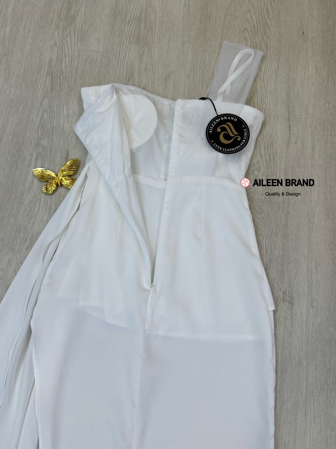 เดรสยาวสีขาวดีไซน์เก๋ อกเก็ตล็อคทรงเป็นผ้าลูกไม้ ( เสริมฟองน้ำและซิปหลังซ่อนอย่างดี ) เพิ่มความเก๋ด้วยแต่งผ้าชีฟองสีขาวพาดบ่าหนึ่งข้าง ช่วงกระโปรงทรงตรงยาวผ่าสูงถึงช่วงต้นขา แต่งผ้าอีกชั้นจับจีบไขว้ข้างและติดด้วยเข็มกลัดผีเสื้อสีทองปล่อยชายพริ้วลงมาสวยมาก