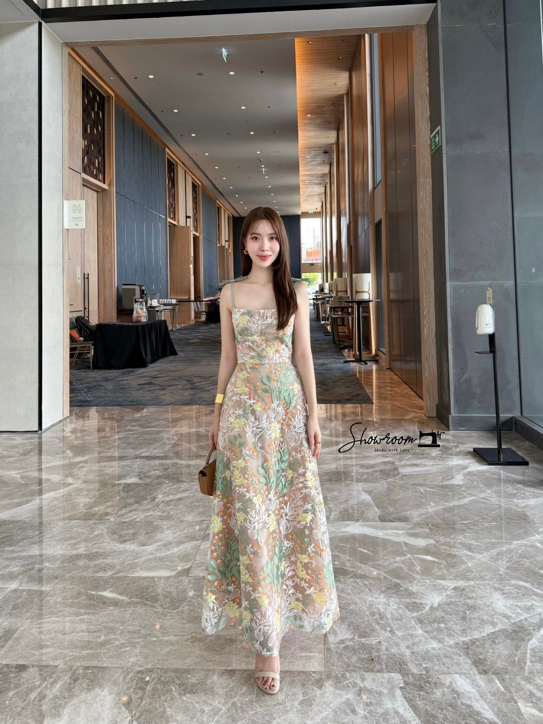 เดรสลูกไม้ทอลายทรงสายเดี่ยวลำตัวเข้ารูปกระโปรงจับจีบระบายแต่งโบว์ไหล่สุดหรู ดีไซน์สวยสะกดสายตา สายสีเขียวติดโบว์ไหล่โดล่างเป็นกระโปรงสุ่มพองบาน เนื้อผ้าลูกไม้ทอลายนูนสลับสีส้มเขียวขาว ให้ลุคที่ทั้งเซ็กซี่และนุ่มนวลในเวลาเดียวกัน คอมพลีทลุคครบจบในชุดเดียวค