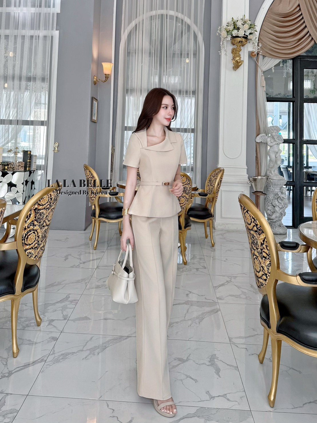 เซต3ชิ้นเสื้อผ้าสูทคอปกสูทเฉียงแขนสั้นเข้ารูปเข้าเอวชายทรงบานออกมาพร้อมกางเกงขายาวทรงกระบอกกลางตีเกล็ดหน้ายาวทำให้ดูผอมมีกระเป๋ากางเกงใส่เข้าชุดกับเข็มขัดสีเดียวกับชุดทั้งชุดเป็นผ้าสูทอัดกาวผ้ามีน้ำหนัก