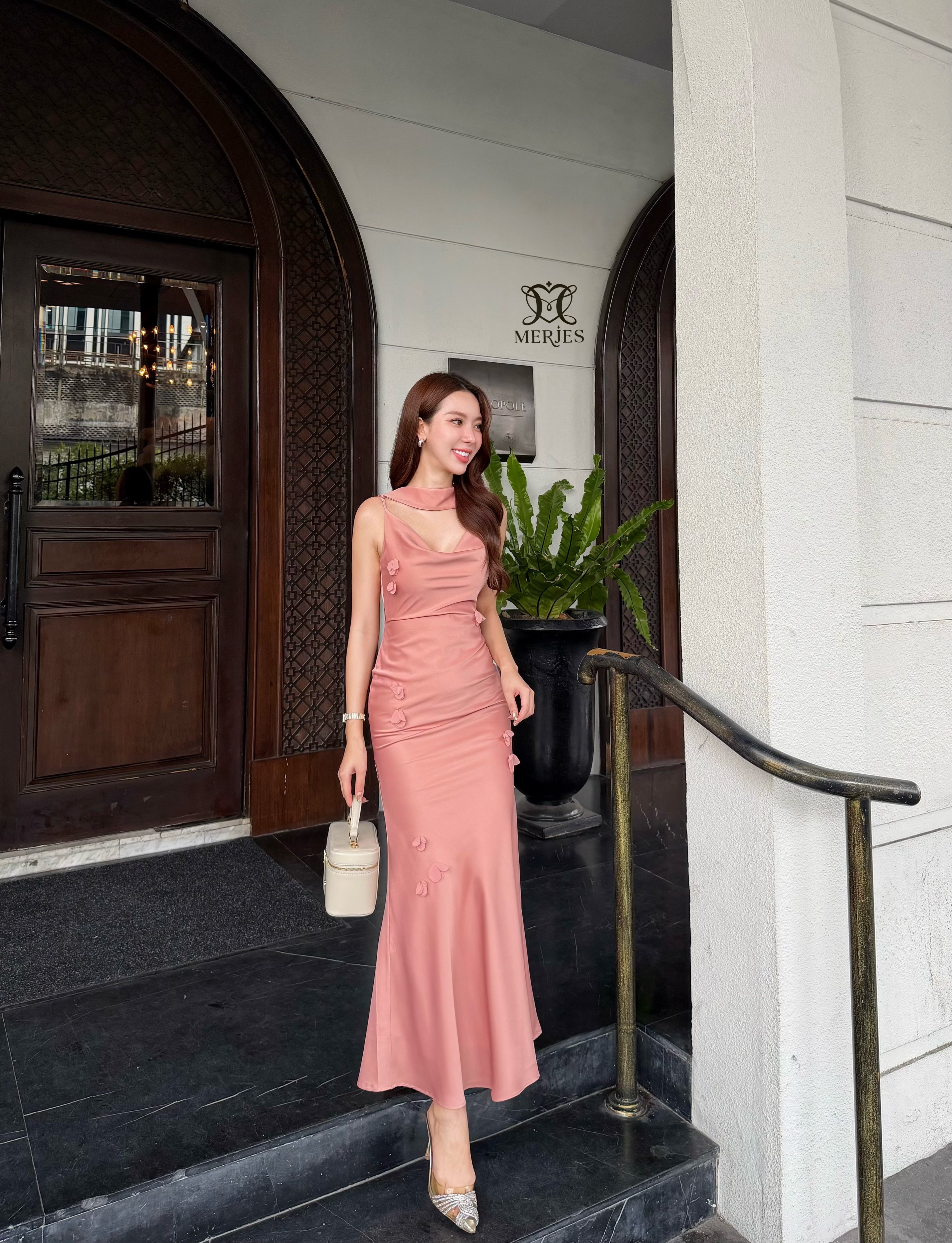 เดรสยาวสีชมพูนู้ดผ้าซาตินสายเดี่ยวเข้ารูปสายสามารถปรับได้แต่งดีเทลด้วยดอกไม้ติดช่วงตัวชุดปลายชุดทรงหางปลาเล็กน้อยเพิ่มความสวยหรูของชุด มาพร้อมผ้าพาดบ่าเพิ่มความเก๋งานมีซับใน