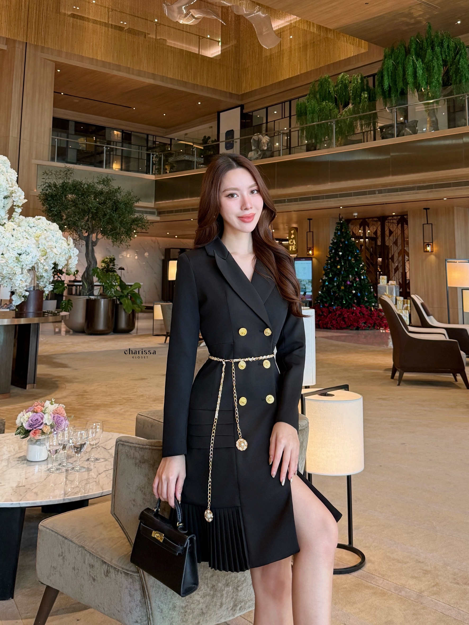 เดรสสูทกระดุมทองทรงหรู สไตล์มินิมอลคลาสสิกที่ออกแบบมาเพื่อเสริมความสง่างามทุกอิริยาบถ ตัวชุดเป็นทรง double-breasted เข้ารูปกำลังดี เน้นสัดส่วนช่วงเอวให้ดูเพรียว เรียบหรูแต่ทรงพลัง กระโปรงด้านล่างตัดต่อด้วย ดีเทลพลีท (Pleated Hem)