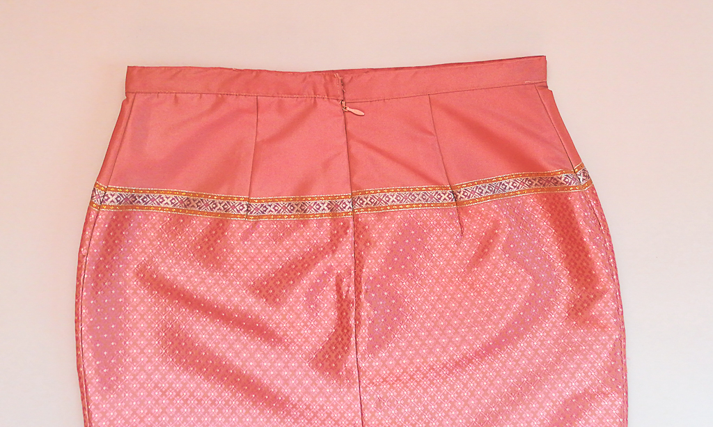 ผ้าถุงไหมสำเร็จรูป (สีชมพูอ่อน ลายสุโขทัย ทรงกระโปรง) งานตัดเย็บประณีต อัดผ้ากาวตามสีของผ้าถุง เนื้องานดีเกรด A (รอบเอว 30 นิ้ว)