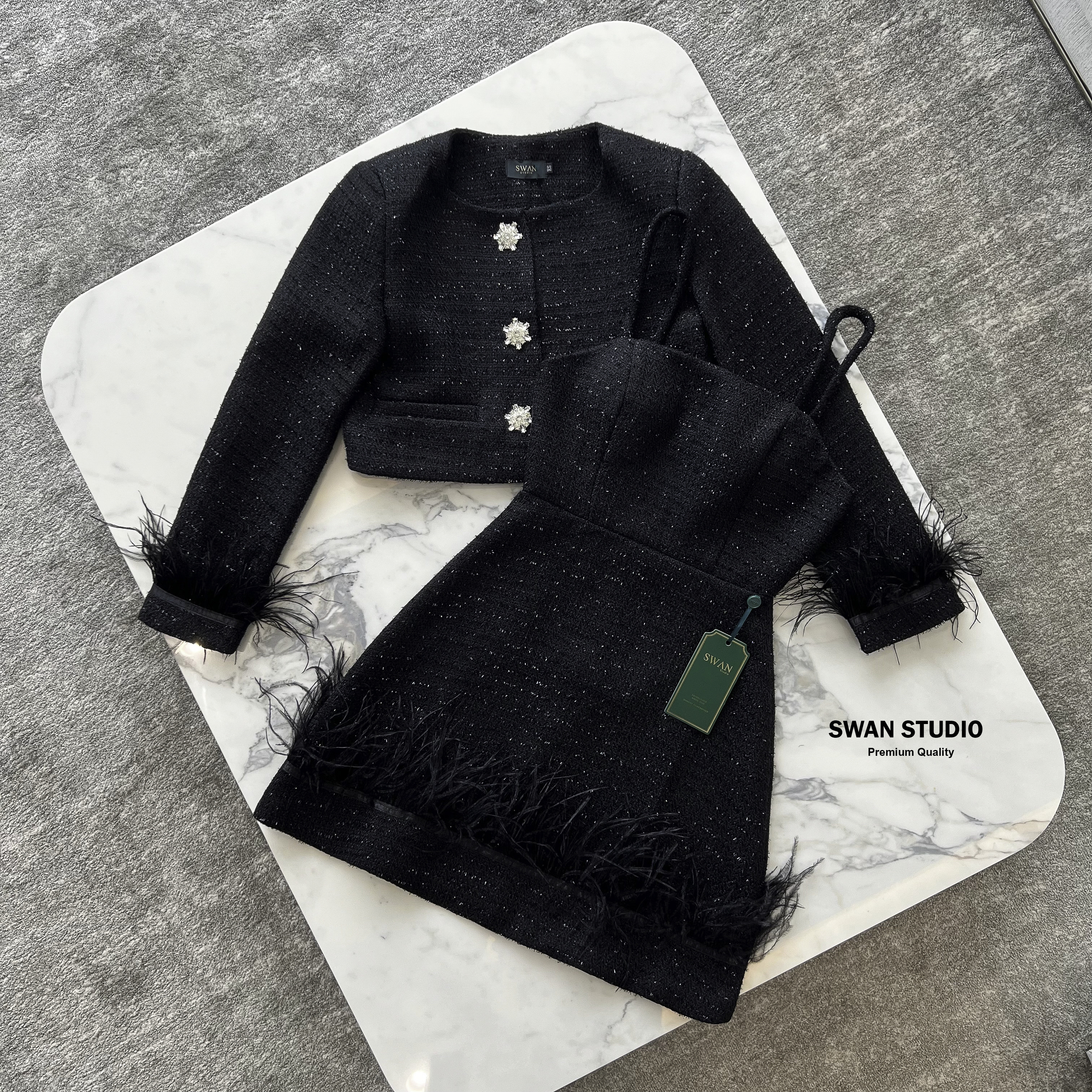 เซทเสื้อคลุมแขนยาวผ้าทวิตสีดำ แต่งกระดุมเพชรดอกไม้ ปลายแขนแต่งขนนก + มินิเดรสเกาะอก แต่งปลายเดรสด้วยขนนก สวยดูแพงมาก ห้ามพลาดค่า