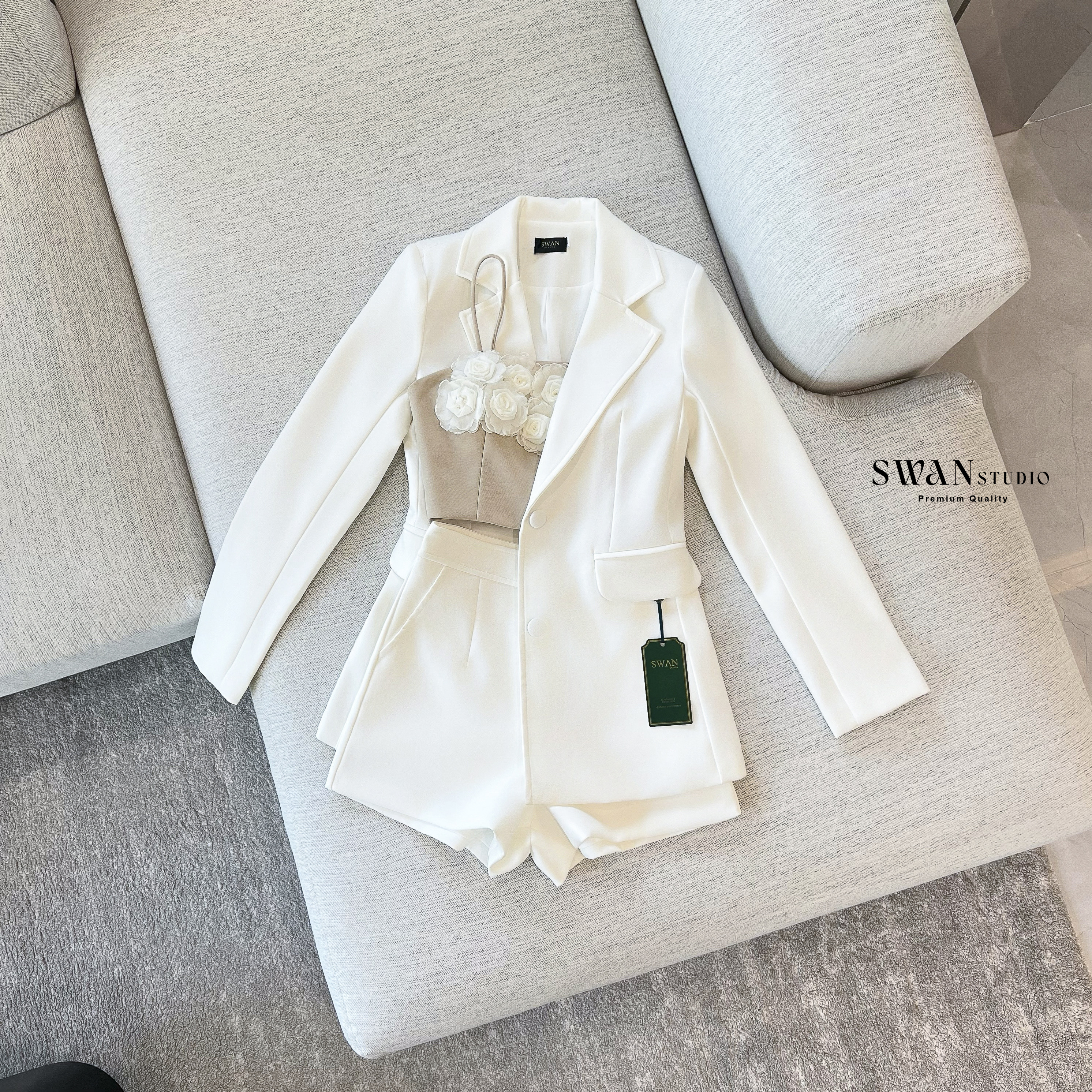 Set 3 ชิ้น ประกอบด้วยเบลเซอร์แขนยาวทรงเข้ารูป มิกซ์เข้ากับกางเกงขาสั้นเอวสูงที่ช่วยให้ลุคดูขาเรียวยาว ด้านในแมทช์กับเสื้อครอปสายเดี่ยวโทนเบจตกแต่งดอกกุหลาบสามมิติสีขาวเรียงแถวด้านหน้าอย่างประณีต