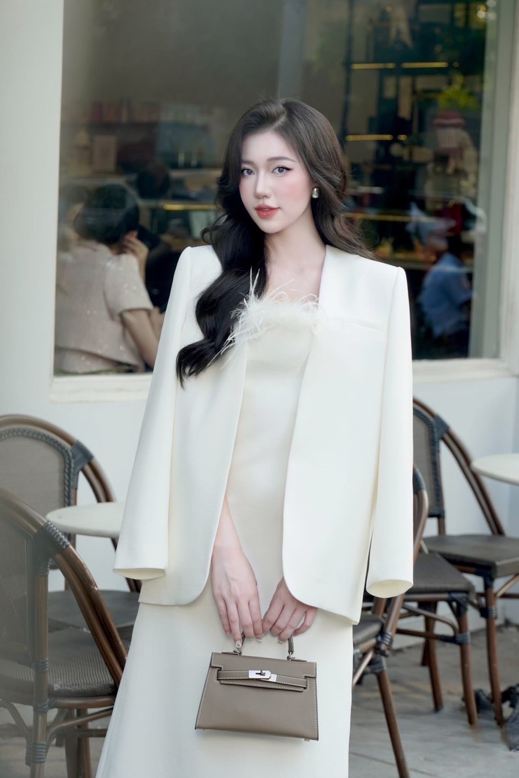 เดรสยาวสีขาวสายสปาเกตตี้ช่วงอกตรงขอบแต่งขนนก ตัวเดรสทรงพอดีตัวยาวถึงข้อเท้า เนื้อผ้าไม่บางมีซับในทั้งตัว ( อกเสริมฟองน้ำและซิปหลังซ่อนอย่างดี ) มาพร้อมกับเสื้อสูทคลุมด้านนอกสีเดียวกันกับเดรส สูททรงปล่อยแขนยาวไม่มีกระดุม สวยหรูมากๆค่ะ