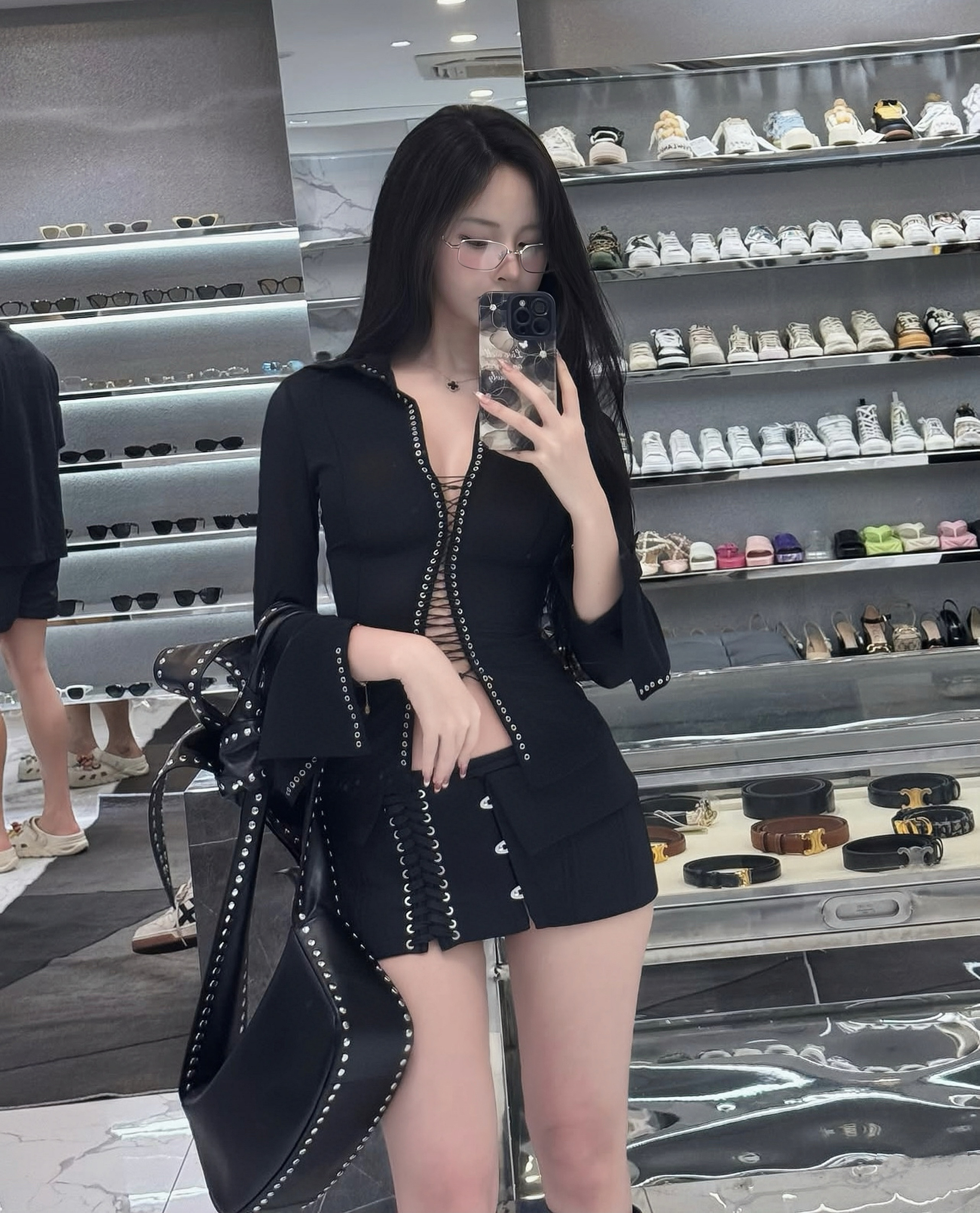 เสื้อผ้าชุดนี้มาในดีไซน์สไตล์เท่จัดจ้าน ตัวเสื้อทรงเข้ารูปมีดีเทลรูตาไก่ร้อยเชือกตรงกลางและปลายแขน เพิ่มความเปรี้ยวด้วยคัตเอาท์ช่วงเอวเล็กน้อย เข้าชุดกับกระโปรงมินิสเกิร์ตดีไซน์เอวต่ำที่ตกแต่งด้วยเชือกร้อยด้านหน้าและตาไก่ด้านข้าง
