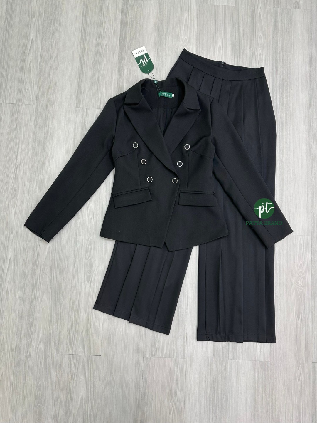 Set 2 ชิ้นสีดำ เสื้อสูททรงเข้ารูปแขนยาวคอปก แต่งกระดุมสีดำขอบเงินตั้งแต่ช่วงอกโค้งลงมาช่วงเอว เป็นกระดุมคู่ใช้งานได้จริง กระเป๋าล้วงที่เสื้อทั้งสองข้าง เนื้อผ้าหนามีซับในทั้งชุด มาพร้อมกับกางเกงขายาวเนื้อผ้าสีดำอัดจีบรอบตัวให้ดูคล้ายกระโปรงมีกระเป๋าล้วงทั