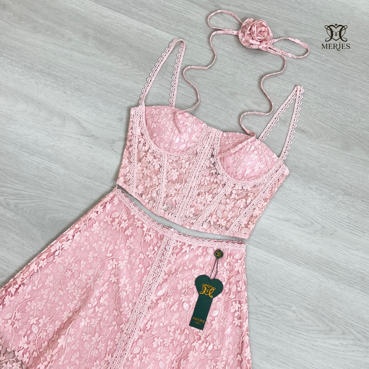 เซตผ้าลูกไม้สีชมพูสายเดี่ยวแต่งผ้าฉลุ สายเดี่ยวทรงสั้นเข้ารูปพร้อมฟองน้ำเสริมอกเพื่อให้ทรงสวยตีเกล็ดฉลุรวบอกและช่วงตัว มาพร้อมกับกระโปรงยาวทรงบานดีเทลแต่งผ้าฉลุด้านหน้ากระโปรงมีซับครึ่งตัวงานซิปหลังทั้งเสื้อและกระโปรง มีเชือกและดอกไม้เข็มกลัดจะใช้ที่คอหรื