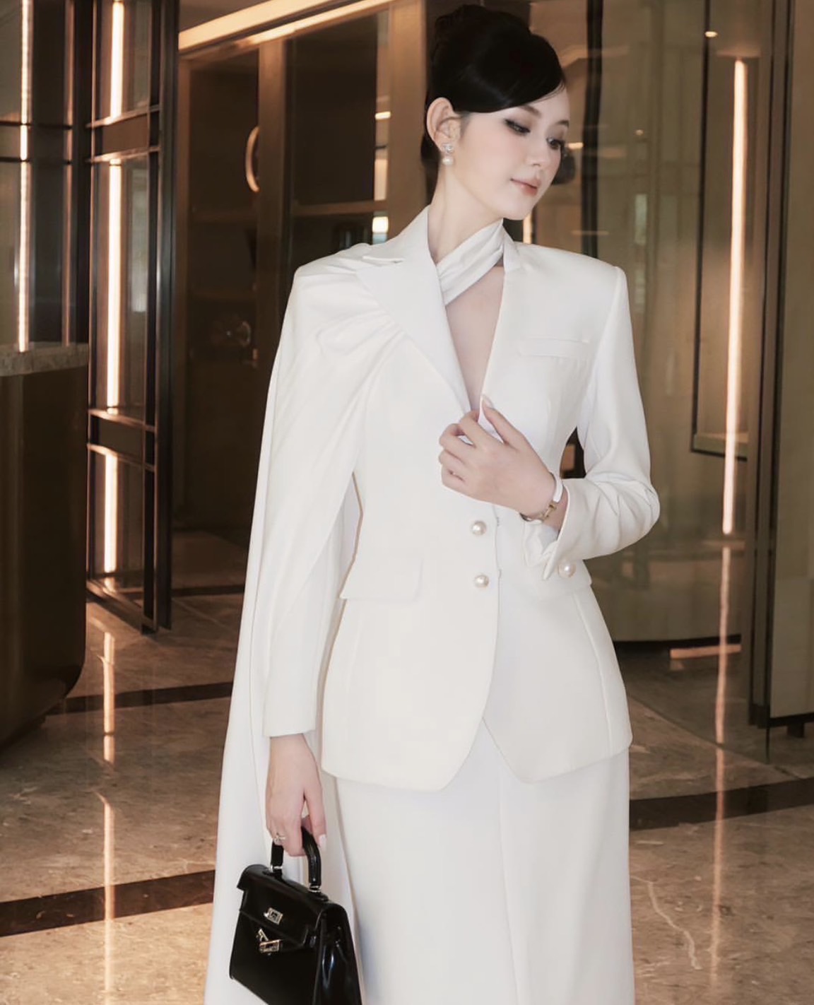 เซ็ตเสื้อสูทเบเซอร์สีขาวแขนยาว มีกิมมิคช่วงคอเป็นผ้าพาดหางปลายาว มาคู่กับกระโปรงทรงสอบสีขาว #pisamaibrand #ชุดไปงาน #ชุดทำบุญ #ceolook #ชุดสูท