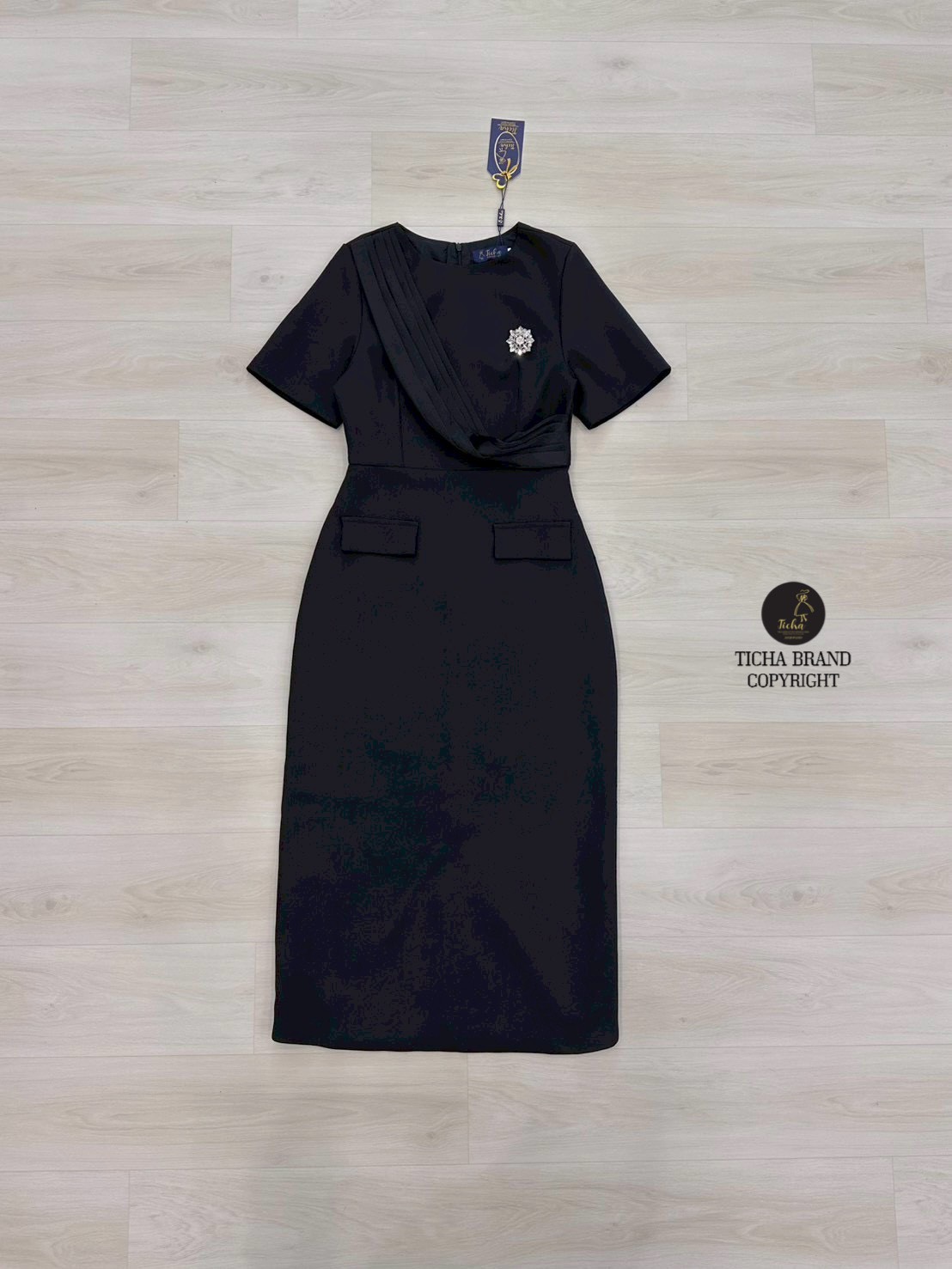 ชุดเดรสสีดำ แขนสั้นคอกลม แต่งผ้าคาดช่วงอก แต่งปกกระเป๋า ( ซิปหลัง) เพิ่มความหรูหราด้วยเข็มกลัดคริสตัสช่วงกระโปรงยาวทรงสอบ แต่งผ้าหลัง