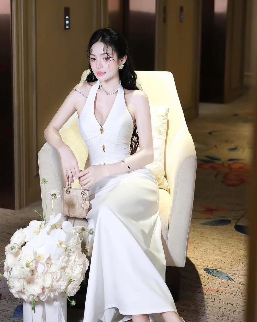 ชุดเดรสคล้องคอยาวสีขาวแต่งกระดุมด้านหน้าสีทองตรงคอมีกระดุมหน้าอกเสริมฟองน้ำ งานซิปหลังรุ่นนี้ผ้าหนางานสวยมากมาในแนวเรียบหรูชุดเดรสยาว