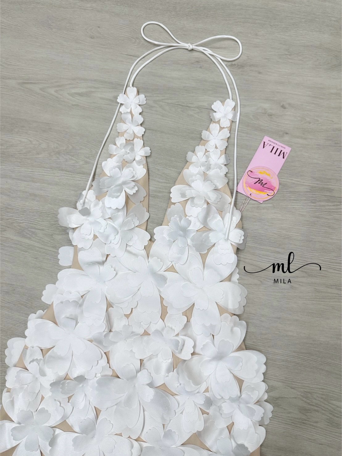 Must-Have Item! มินิเดรสสุดหรูแต่งด้วยดอกไม้ 3 มิติสีขาวนูนเด่นทั่วทั้งชุด บนฐานผ้าสีนู้ดที่ช่วยขับผิวพร้อมดีเทลสายคล้องคอ Halter Neck ที่ปรับได้ โชว์หลังสับ ๆ ( ซิปหลังซ่อนอย่างดี ) ทำให้หุ่นดูเพรียวสวยเป๊ะ! ใส่ไปปาร์ตี้หรือออกเดทก็รับรองว่าเกิดสุดๆ ห้าม