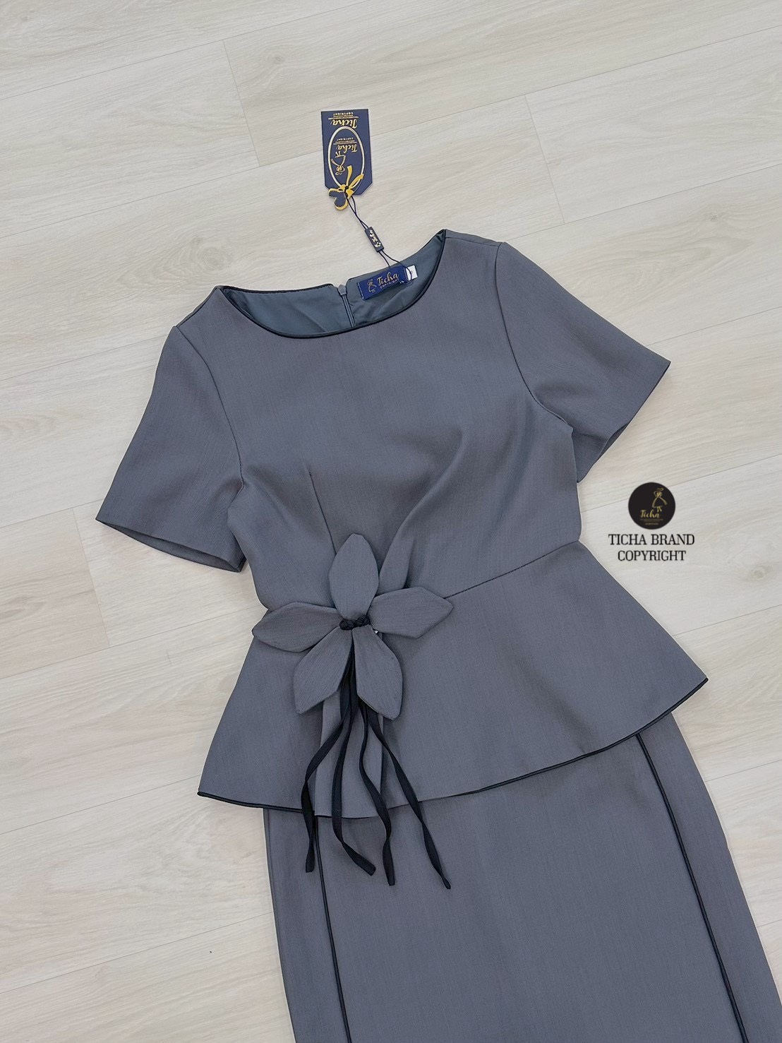 ชุด Set3ชิ้น เสื้อแขนสั้นสีเทา ดีเทลแต่งระบายและกุ้นสีดำชายเสื้อ (อกเสริมฟองน้ำ ซิปหลัง) และมีเข็มกลัดดอกไม้ มาพร้อมกระโปรงสีเทาทรงสอบดีเทลผ่าหลัง แต่งกุ้นสีดำด้านหน้าดีไซน์สวย (มีซิปหลัง)