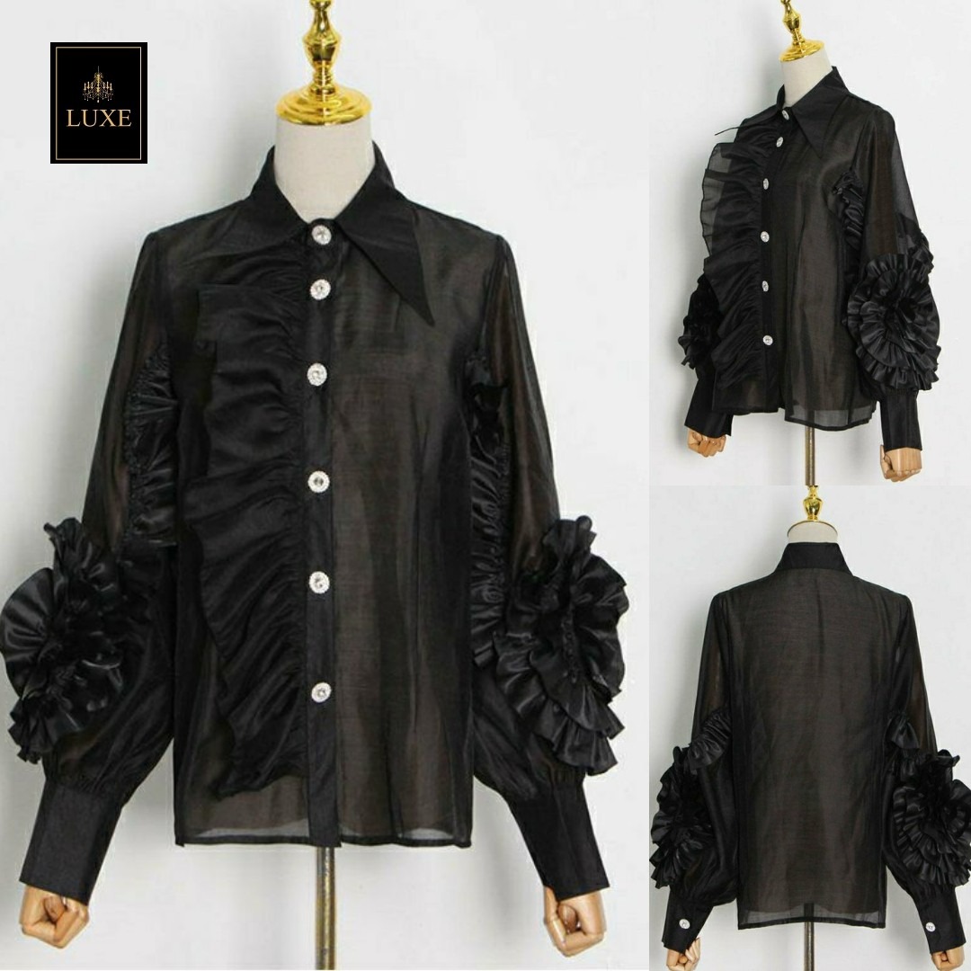 Label : LUXE เสื้อเชิ้ตคอปกแหลมแขนยาว ผ่าหน้าติดกระดุมเพชร สาบเสื้อแต่งระบาย ดีเทลแขนเสื้อแต่งด้วยผ้าในตัวเป็นรูปดอกไม้ ทำจากผ้าไหมเครปผสม เนื้อนุ่ม โปร่ง เบาสบายแต่ให้ความเป็นทรง