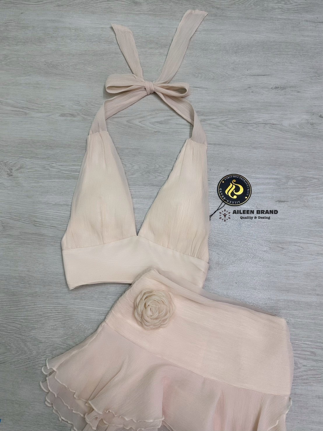 Set 2 ชิ้น เสื้อคล้องคอสีครีม แต่งคอวีเว้าลืก อกเสริมฟองน้ำ (ซิปหลัง) แมทซ์กับกางเกงกระโปรง ด้านนอกแต่งระบายเป็นชั้นๆ ดีเทลชับในเป็นกางเกง (ซิปข้าง) มาพร้อมเข้มกลัดดอกไม้ ใส่คู่กัน สวย แซ่บ อย่างลงตัว