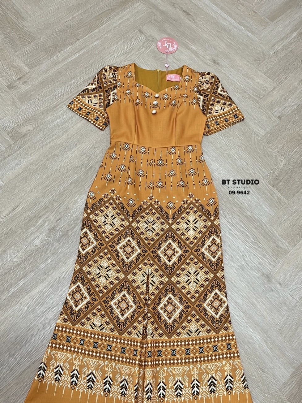 เดรสยาวผ้าไทยดีเทลแต่งคอเว้าเล็กน้อย แขนสั้น แต่งกระดุมมุก 3 เม็ดเรียงกัน ดีไซส์ผ้าพิมพ์ลายไทยประยุกต์ งานสวยเนื้อผ้าดีมีซับในคัตติ๊งสวยจ้า