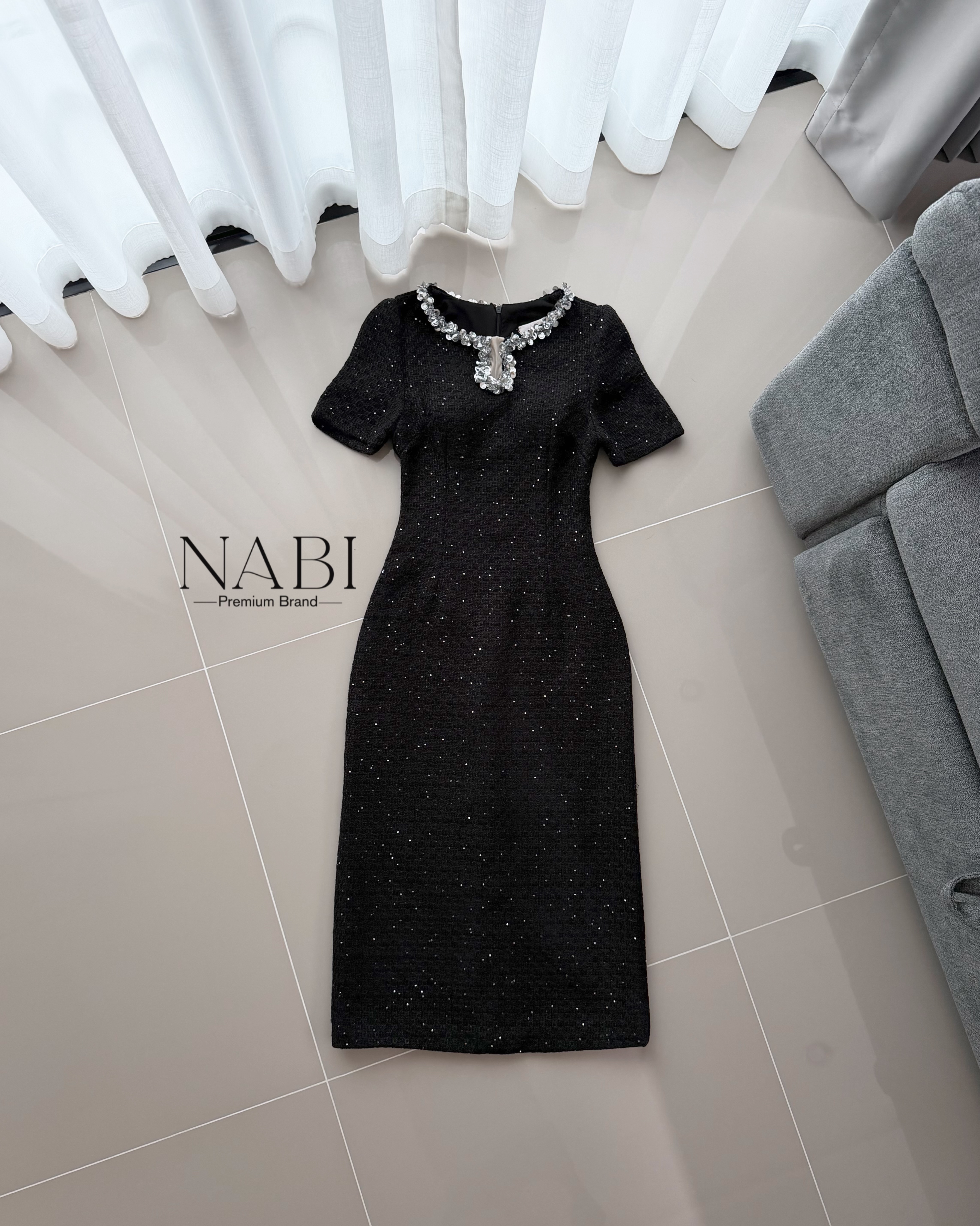 ชุดเดรสทรงเชฟเข้ารูปแขนสั้น ความยาวมิดเข่า ดีไซน์คอกลมตกแต่งมุกคลิตเตอร์เป็นแถบล้อมรอบคอ และแต่งผ้าซีทรู ใช้ผ้าทวีดเนื้อหนาที่มีพื้นผิว ประดับด้วยเม็ดกลิตเตอร์เล็กทั่วผืน ให้ประกายเป็นจุด ๆ เรียบแต่หรูดูแพง มีซับในและฟองน้ำ งานซิปซ่อนด้านหลัง ผ่าด้านหลัง