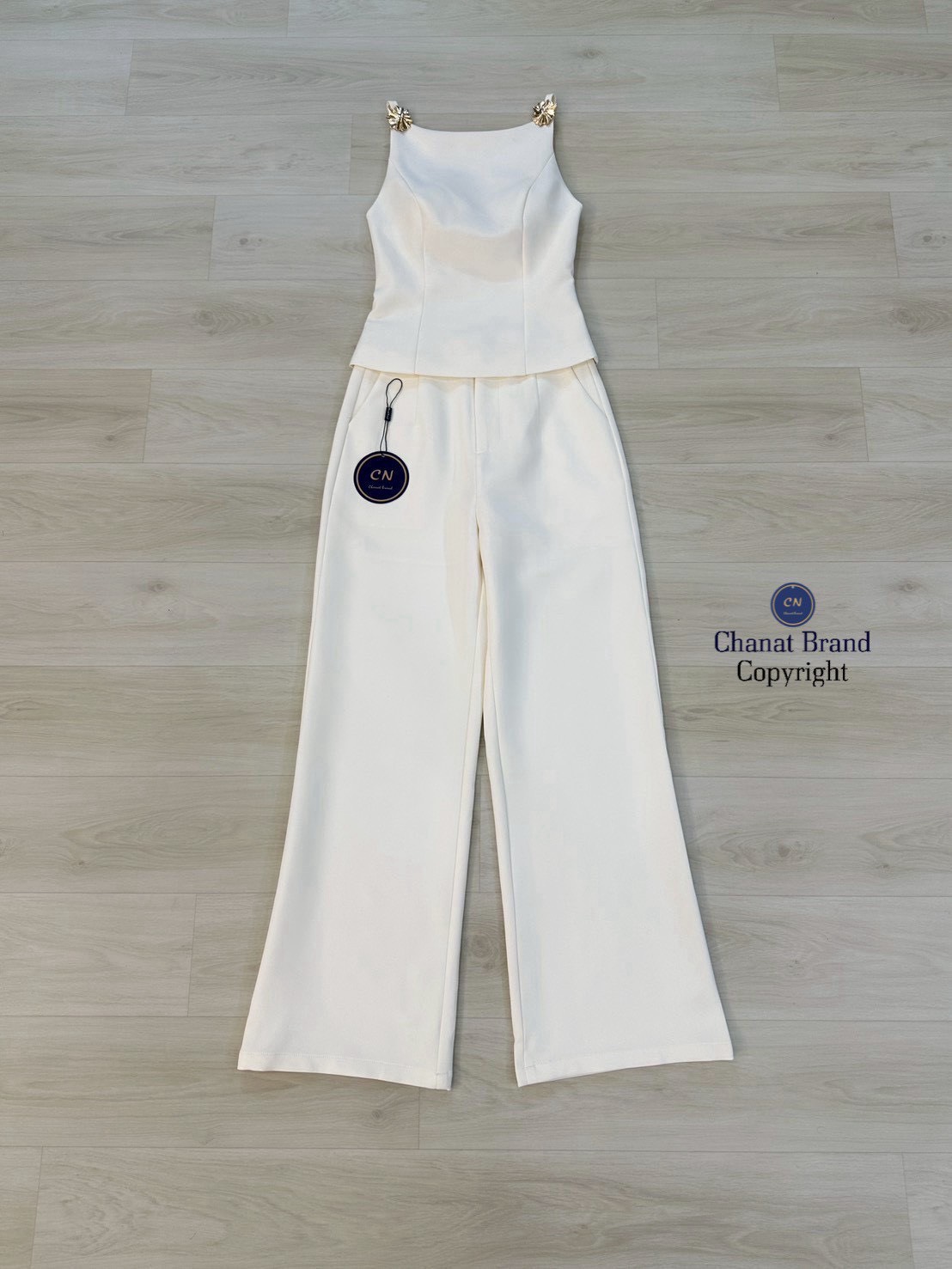 Set 2 ชิ้น เสื้อสายเดี่ยวสีครีม ช่วงสายด้านหน้าแต่งอะไหล่ดอกไม้สีทอง อกเสริมฟองน้ำ ดีเทลแต่งเว้าหลังบน ซิปหลังมีชับในตัว แมทซ์กับกางเกงขายาว สีเดียวกับชุด มีตะข้อและซิปหน้า กระเป๋าข้างใช้งานได้จริง งานสวย เนื้อผ้าดี คัตติ๊งเป๊ะคะ