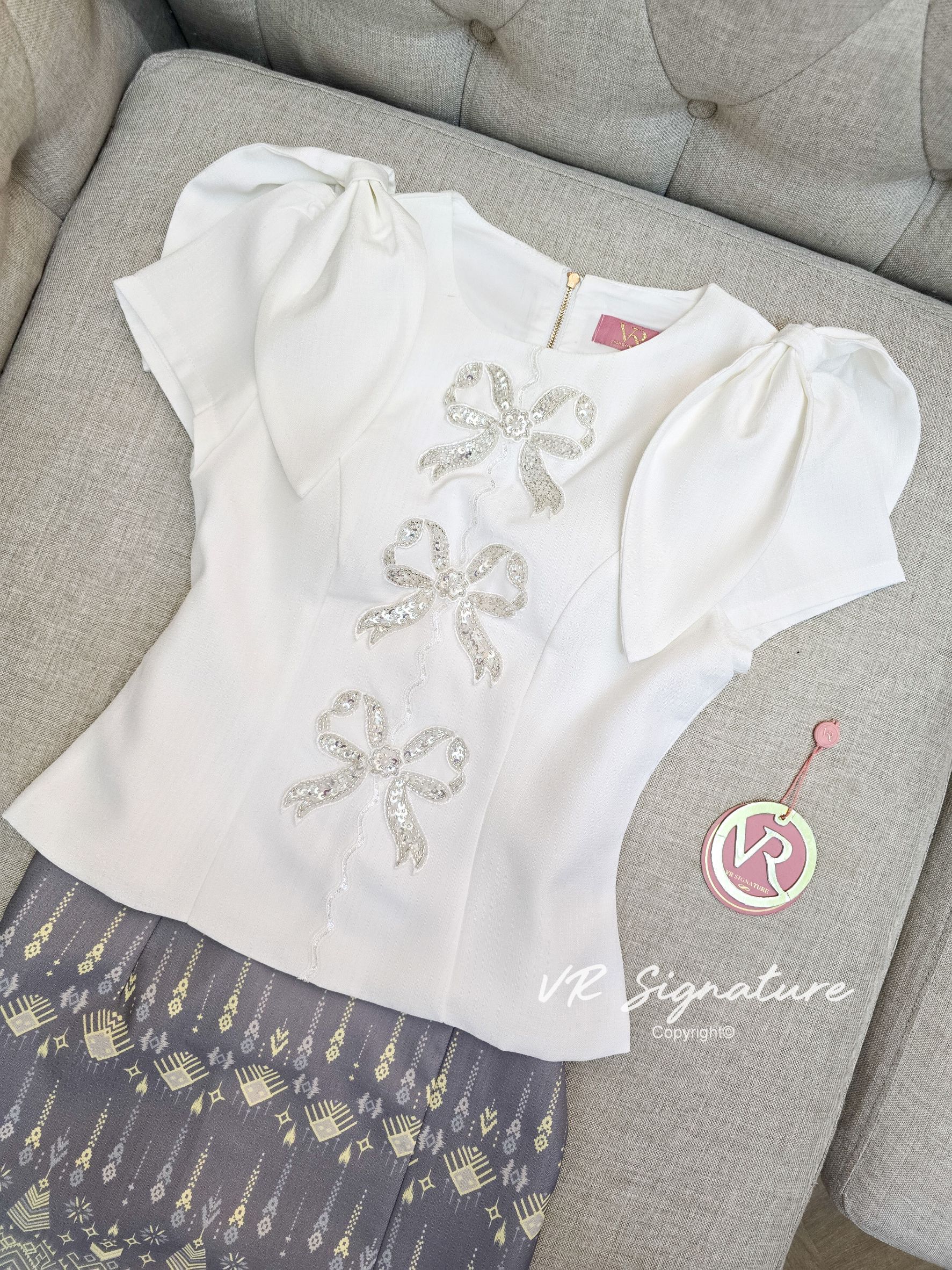 Set เสื้อแขนสั้นแต่งโบว์ ด้านหน้าแต่งโบว์ปักเลื่อมเรียงสวยมากค่ะ มีฟองน้ำจัดทรงให้ด้วยค่ะ ชายเสื้อบานเล็กน้อย แมทช์กับกระโปรงยาวทรงพับจีบทบด้านข้าง เนื้อผ้าพิมพ์ลายไทย มี texture สวยมากค่ะ มีซับใน สามารถใส่แยกกับชุดอื่นได้อีกเยอะเลยค่ะ ต้องจัดนะค่