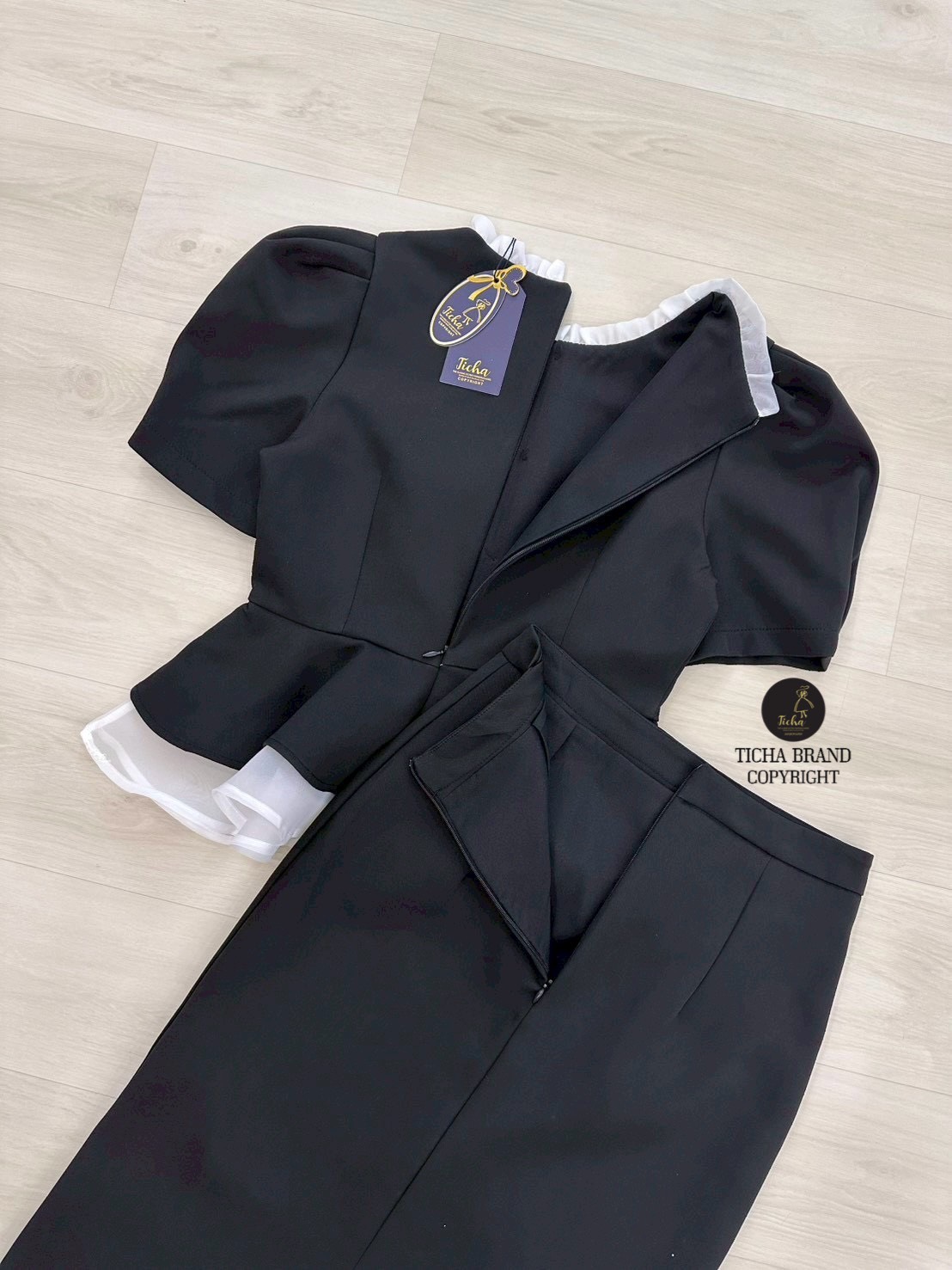 ชุด Set2ชิ้น เสื้อแขนสั้นสีดำทั้งชุด คอกลมแต่งระบาย แต่งระบายผ้าแก้วสีขาวชายเสื้อและแต่งอ่ะไหล่กระดุมทอง (มีซิปหลัง) มาพร้อมกระโปรงทรงสอบดีเทลผ่าหลัง ดีไซน์สวย