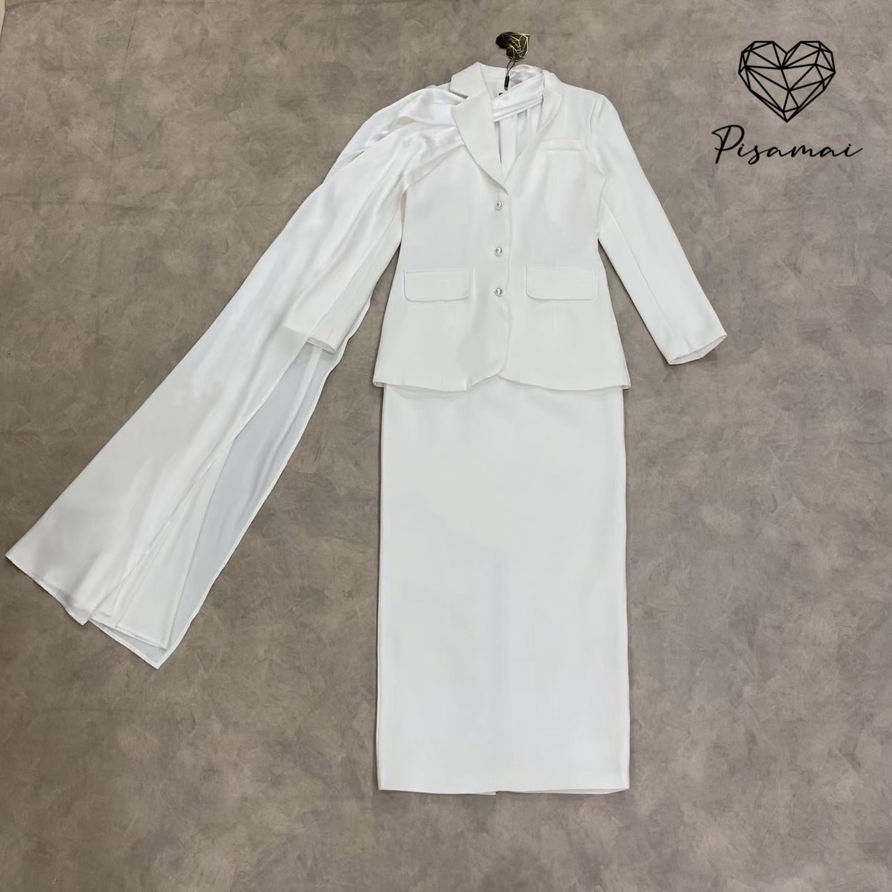 เซ็ตเสื้อสูทเบเซอร์สีขาวแขนยาว มีกิมมิคช่วงคอเป็นผ้าพาดหางปลายาว มาคู่กับกระโปรงทรงสอบสีขาว #pisamaibrand #ชุดไปงาน #ชุดทำบุญ #ceolook #ชุดสูท