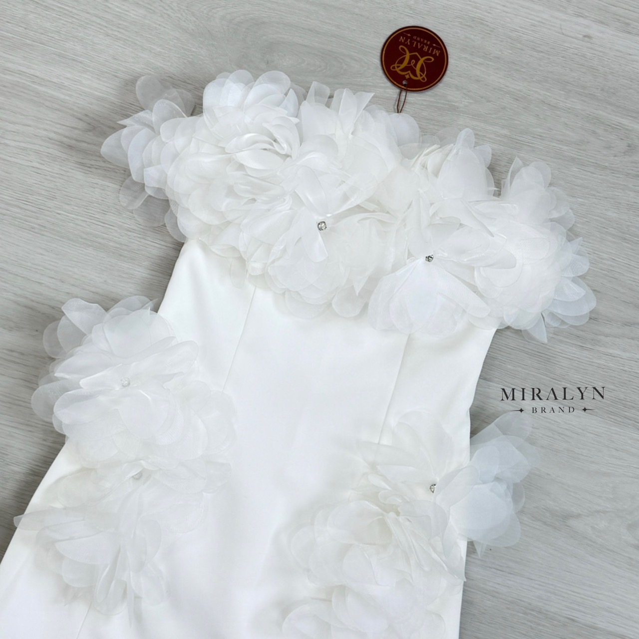 เดรสเกาะอกสีขาวทรงเข้ารูป แต่ง detail ด้วยดอกไม้ช่วงอกแน่นๆและเย็บด้วยเพชรเป็นเกสรและแต่งดอกไม้ที่ช่วงสะโพกทั้งสองข้างอกมีฟองน้ำเสริมและมีซับทั้งตัว #Miralynstudio#Miralynbrand#miralynชุดออกงาน#เดรสออกงาน#ชุดดินเนอร์