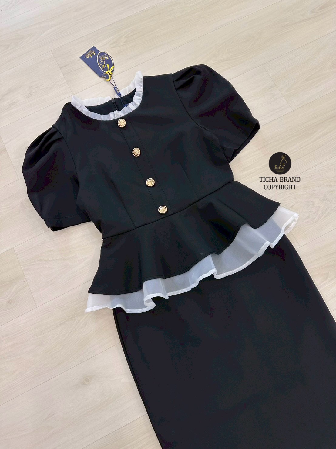 ชุด Set2ชิ้น เสื้อแขนสั้นสีดำทั้งชุด คอกลมแต่งระบาย แต่งระบายผ้าแก้วสีขาวชายเสื้อและแต่งอ่ะไหล่กระดุมทอง (มีซิปหลัง) มาพร้อมกระโปรงทรงสอบดีเทลผ่าหลัง ดีไซน์สวย