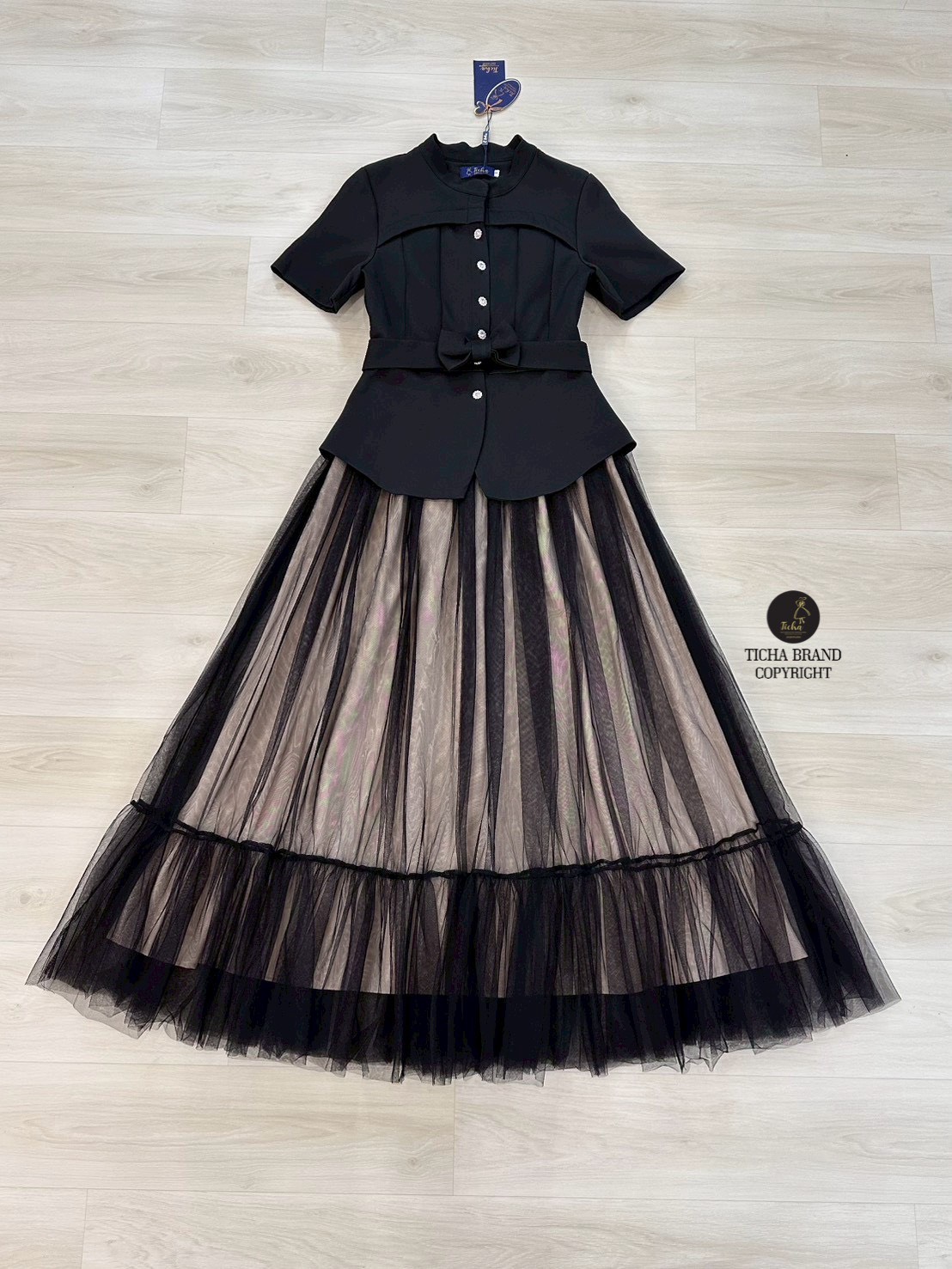 Set 2 ชิ้น สีดำเสื้อเบเซอร์คอจีนแขน ด้านหน้าดีเทลตีเกร็ตโค้งสวย และแต่งกระดุมดอกไม้เพชรเรียงยาวใช้งานได้จริงมาพร้อมเข็มขัดโบว์มรกระดุมแป๊ก มาคู่กับกระโปรงยาว แต่งผ้ามุ้งตาข่ายคลุมด้านนอกสีดำ มีชับในสีครีม(ซิปหลัง) งานสวย เนื้อผ้าดี คัตติ๊งเป๊ะคะ