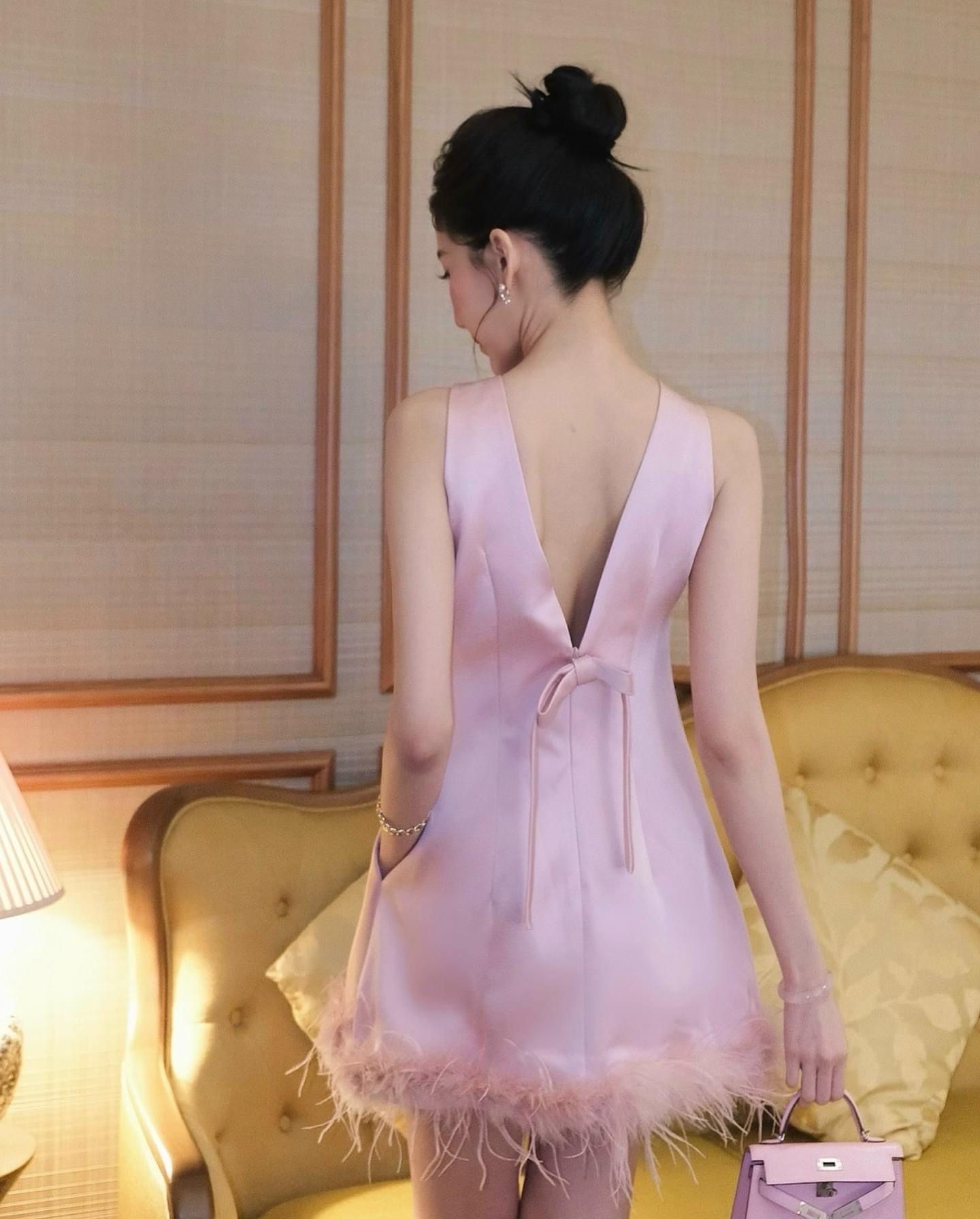 มินิเดรสแขนกุดสีชมพู ติดโบว์สำเร็จตรงกลางคอ อกมีเสริมฟองน้ำ ชายเดรสแต่งด้วยขนนก ด้านหลังผ่า V พร้อมติดโบว์ น่ารักลูกคุณหนู ห้ามพลาดค่า