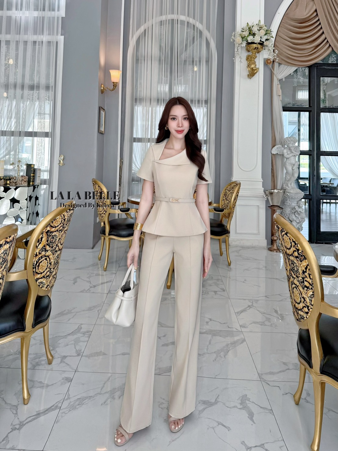 เซต3ชิ้นเสื้อผ้าสูทคอปกสูทเฉียงแขนสั้นเข้ารูปเข้าเอวชายทรงบานออกมาพร้อมกางเกงขายาวทรงกระบอกกลางตีเกล็ดหน้ายาวทำให้ดูผอมมีกระเป๋ากางเกงใส่เข้าชุดกับเข็มขัดสีเดียวกับชุดทั้งชุดเป็นผ้าสูทอัดกาวผ้ามีน้ำหนัก