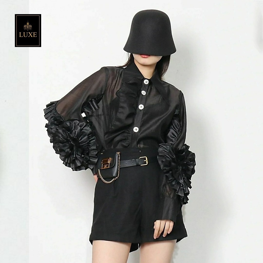 Label : LUXE เสื้อเชิ้ตคอปกแหลมแขนยาว ผ่าหน้าติดกระดุมเพชร สาบเสื้อแต่งระบาย ดีเทลแขนเสื้อแต่งด้วยผ้าในตัวเป็นรูปดอกไม้ ทำจากผ้าไหมเครปผสม เนื้อนุ่ม โปร่ง เบาสบายแต่ให้ความเป็นทรง