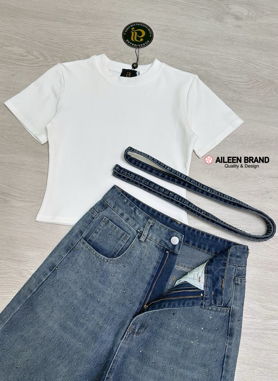 Set 3 ชิ้น เสื้อทรงเบบี้ทรีสีขาวเนื้อผ้านิ่มไม่บางคอกลมแขนกุด ทรงพอดีตัวเอวไม่เต่อ ม่พร้อมกับกางเกงยีนส์เอวสูงสีเข้มฟอกเฟดเป็นลาย กระดุมและซิปด้านหน้ามีกระเป๋าล้วงทั้งสองข้าง ความเก๋คือติดอะไหล่เพชรทั้งตัว วิบวับวิบวับและยังมีเชือกคาดเอวให้อีกเส้น สวยมากๆ