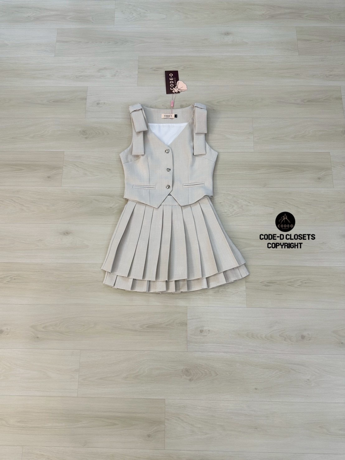 เซต2ชิ้น เสื้อแขนกุดสีครีม กระดุมหน้าหัวใจสีเงิน ดีเทลช่วงไหล่แต่งโบว์เย็บติดมากับตัว กระเป๋าคู่หน้าแต่งหลอก แมทซ์กับกระโปรงสั้นสีเดียวกัน แต่งจับจีบรอบๆตัว ระบายสองชั้น มีชับในกางเกง ซิปข้าง