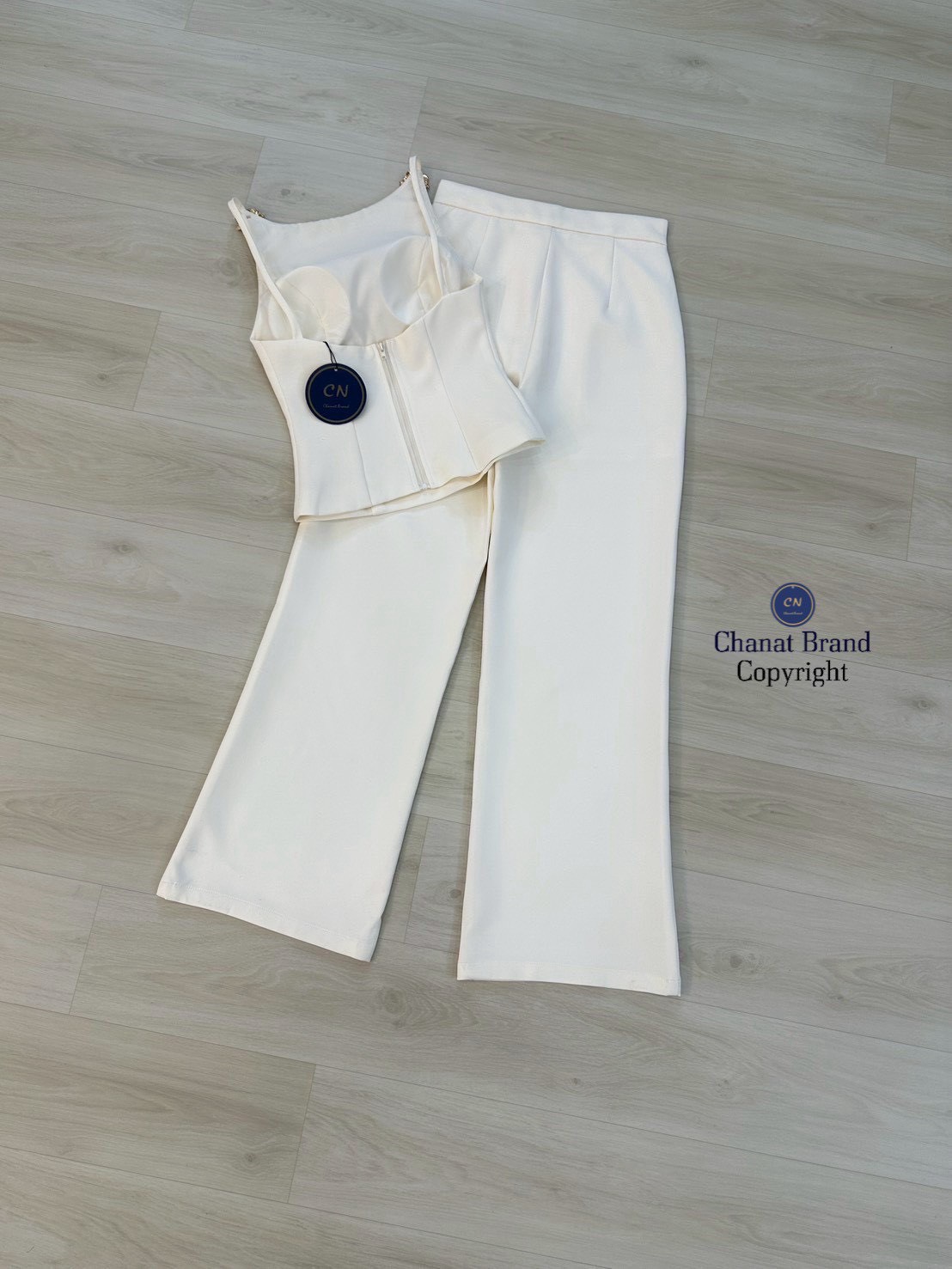 Set 2 ชิ้น เสื้อสายเดี่ยวสีครีม ช่วงสายด้านหน้าแต่งอะไหล่ดอกไม้สีทอง อกเสริมฟองน้ำ ดีเทลแต่งเว้าหลังบน ซิปหลังมีชับในตัว แมทซ์กับกางเกงขายาว สีเดียวกับชุด มีตะข้อและซิปหน้า กระเป๋าข้างใช้งานได้จริง งานสวย เนื้อผ้าดี คัตติ๊งเป๊ะคะ