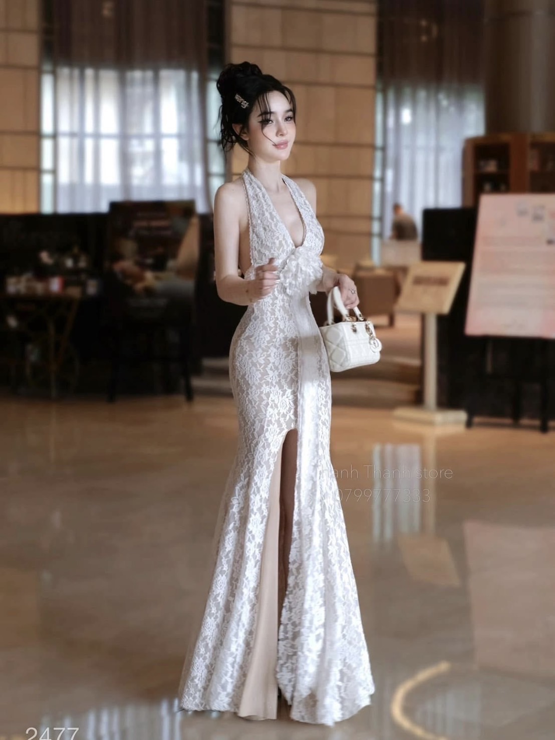 เดรสยาวสีขาวเนื้อผ้าลูกไม้มีซับในสีเนื้อทั้งตัว ดีไซน์แขนกุดคล้องคอมีกระดุมตรงสาย โชว์ครึ่งหลังด้านหน้าช่วงอกเว้าลึก แต่งอะไหล่ดอกไม้สีขาวและริบิบิ้นยาว( เสริมฟองน้ำและซิปหลังซ่อนอย่างดี ) ตัวเดรสทรงเข้ารูปเน้นสัดส่วน ชายกระโปรงทรงบานพลิ้ว ผ่าหน้าสูงปรี๊ด