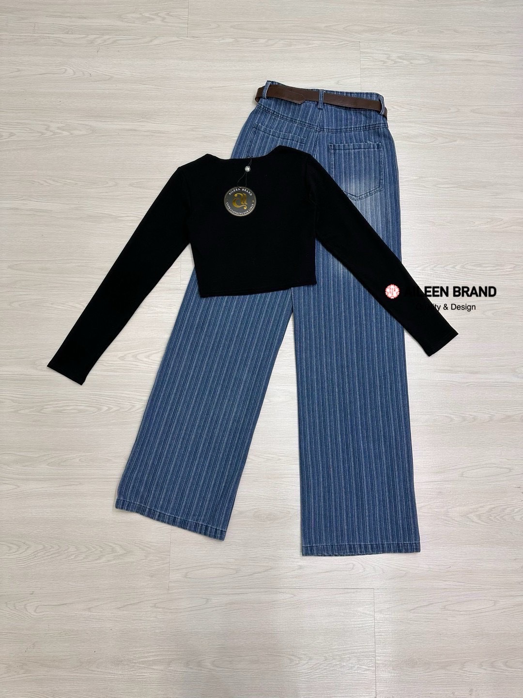 Set 2 ชิ้น เสื้อครอปสีดำแขนยาวทรงพอดีตัว ด้านหน้าสกรีนลายตัวอักษรสีขาว เนื้อผ้านิ่มใส่สบาย มาพร้อมกับกางเกงยีนส์ขายาวสีฟอกแต่งเฟดมีกระดุมและซิปด้านหน้า มีกระเป๋าล้วงทั้งสองข้าง กางเกงทรงกระบอกใหญ่