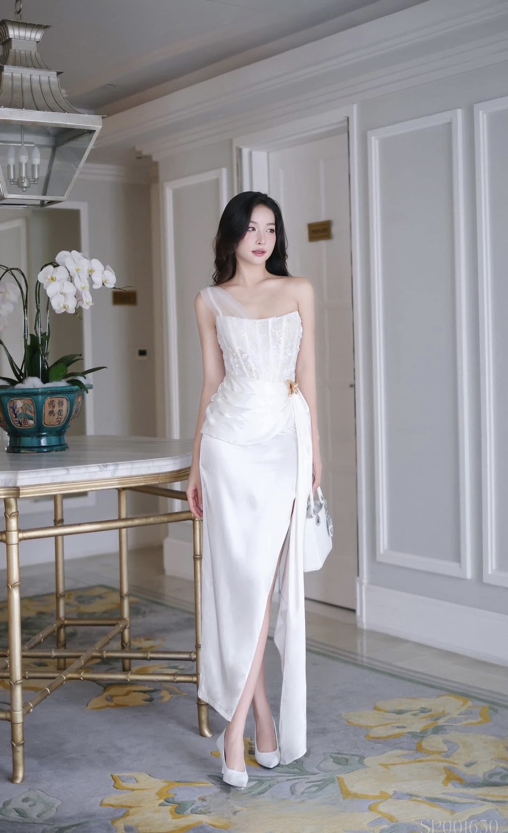 เดรสยาวสีขาวดีไซน์เก๋ อกเก็ตล็อคทรงเป็นผ้าลูกไม้ ( เสริมฟองน้ำและซิปหลังซ่อนอย่างดี ) เพิ่มความเก๋ด้วยแต่งผ้าชีฟองสีขาวพาดบ่าหนึ่งข้าง ช่วงกระโปรงทรงตรงยาวผ่าสูงถึงช่วงต้นขา แต่งผ้าอีกชั้นจับจีบไขว้ข้างและติดด้วยเข็มกลัดผีเสื้อสีทองปล่อยชายพริ้วลงมาสวยมาก