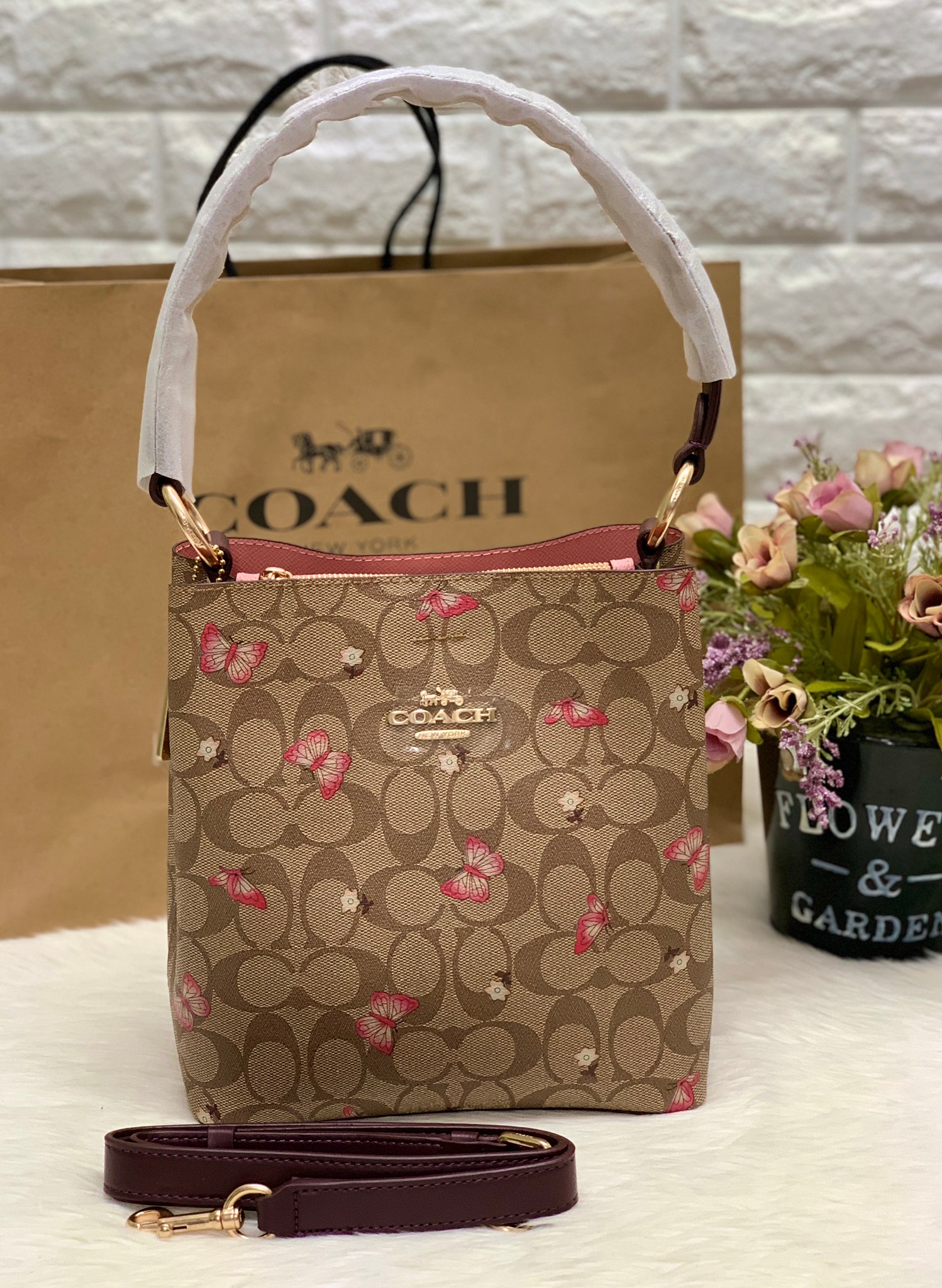 กระเป๋าสะพายทรงถังแบรนด์เนมโค้ชสีน้ำตาลลายC ลายผีเสื้อดอกไม้เก๋ๆ COACH Small Town Bucket Bag in Signature With Butterfly Print 2311