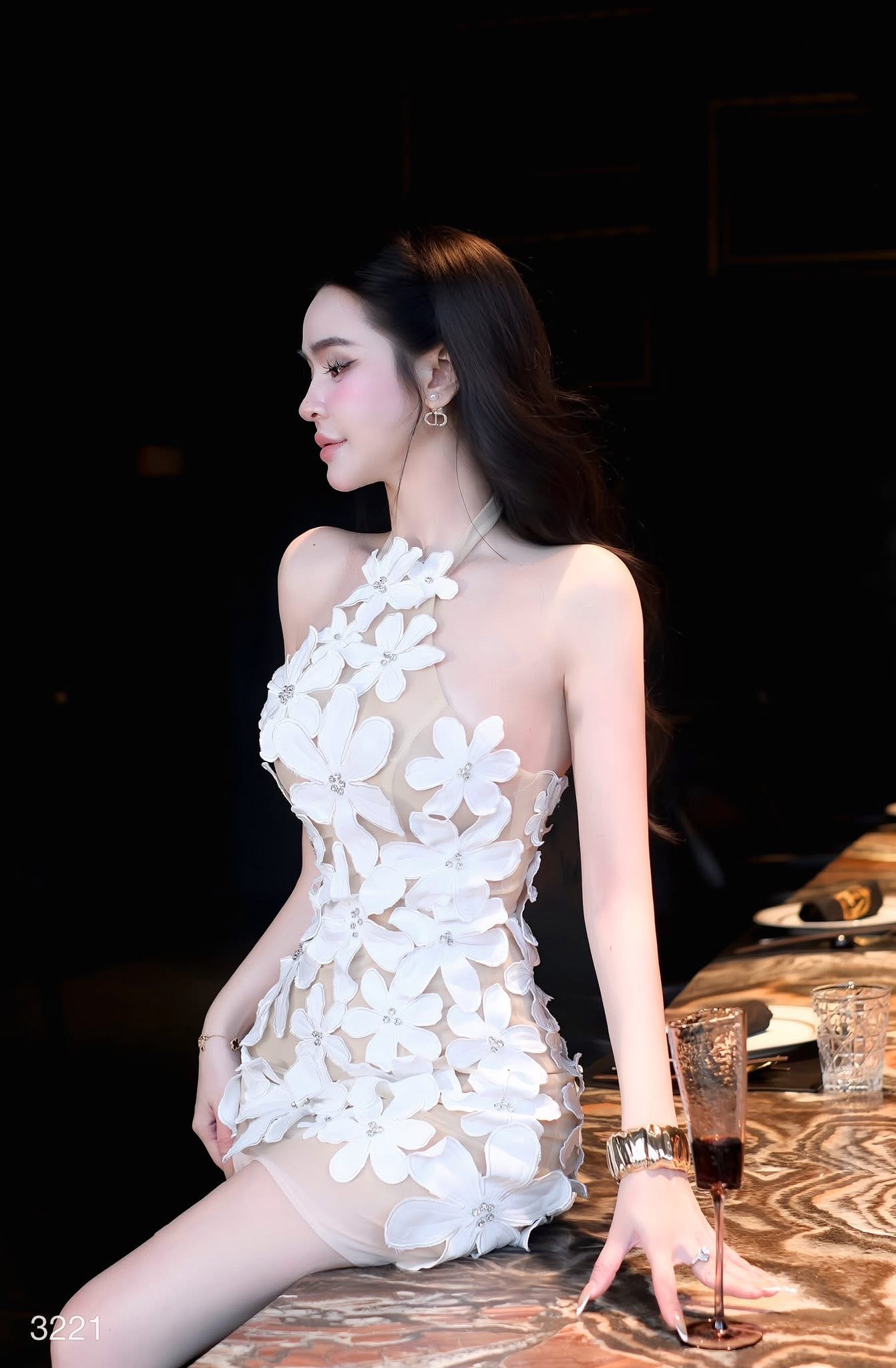 เดรสสั้นดีไซน์สุดโดดเด่นด้วยลายดอกไม้สามมิติทั้งตัว แต่งดอกไม้นูนขนาดเล็ก-ใหญ่ไล่ระดับจากช่วงคอลงมาถึงชายกระโปรง เพิ่มลูกเล่นด้วยการฝังคริสตัลเล็กกลางดอกช่วยสะท้อนแสงอย่างหรูหรา ดีไซน์ชายเดรสเฉียงดูชิคเปรี้ยวมาก ให้ลุคหวานปนเซ็กซี่อย่างลงตัว เ