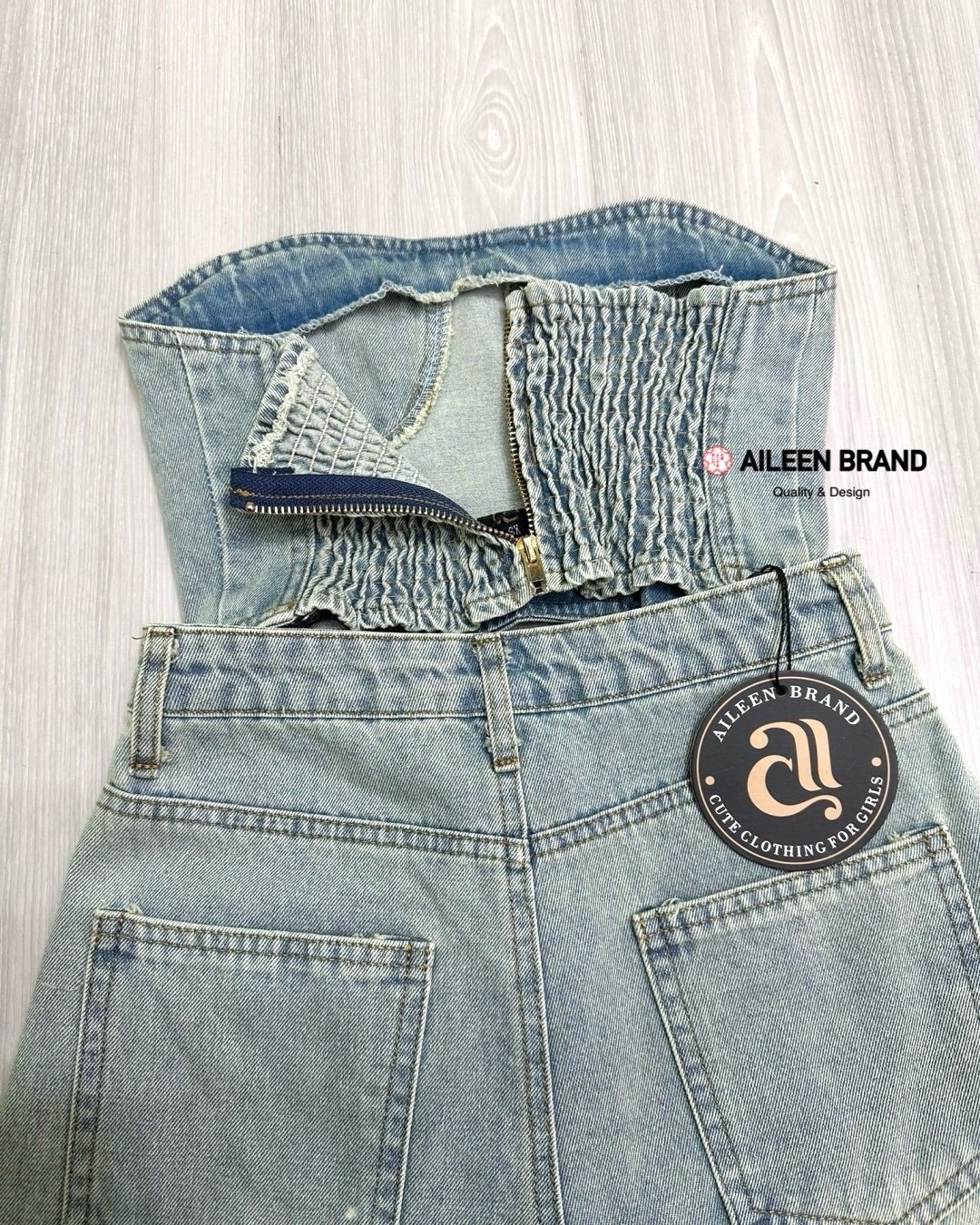 Set 2 ชิ้นผ้ายีนส์สีฟอก เกาอกตัวสั้นอกโค้ง ( ไม่เสริมฟองน้ำและซิปหลังซ่อนอย่างดี ด้านหลังเป็นสม๊อค) เดินตะเข็บแต่งลายให้ตัวชุด เพิ่มความเก๋ด้วยการแต่งขอบเว้าสามารถติดกระดุมเชื่อมกับกางเกงได้ มาพร้อมกับกางเกงขาสั้นเอวสูง มีกระดุมและซิปด้านหน้า มีกระเป๋าล้ว