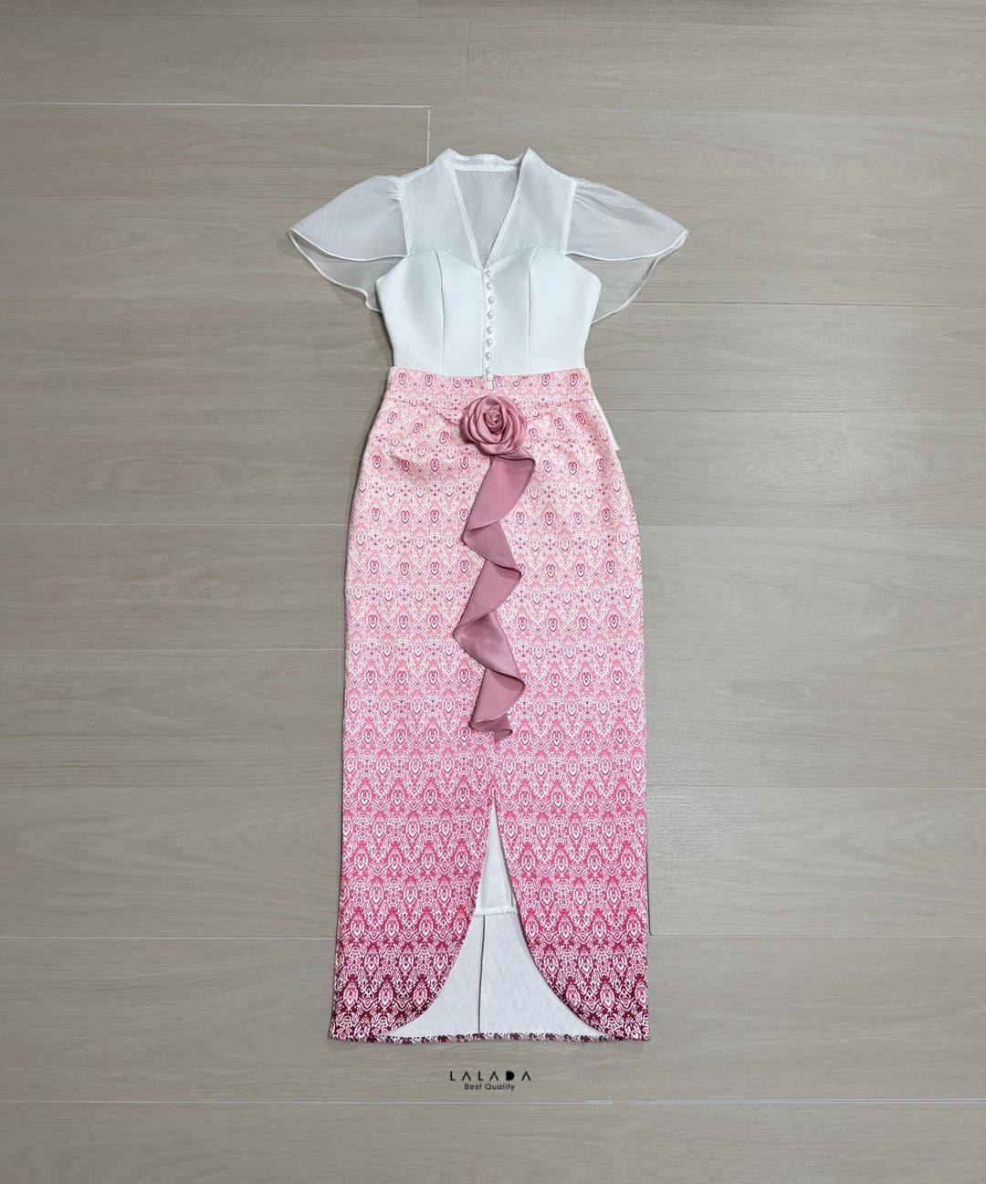 set 2 ชิ้นเสื้อสีขาวกระดุมหน้า ตัดเย็บอย่างดีมีซับใน + กระโปรงผ้าถุงสำเร็จทรงเอวสูง ผ้าพิมพ์ลาย แต่งระบายด้านหน้า+ เข็มกลัดดอกไม้ 1 ชิ้นติดได้ตามต้องการ Color::ตามรูป