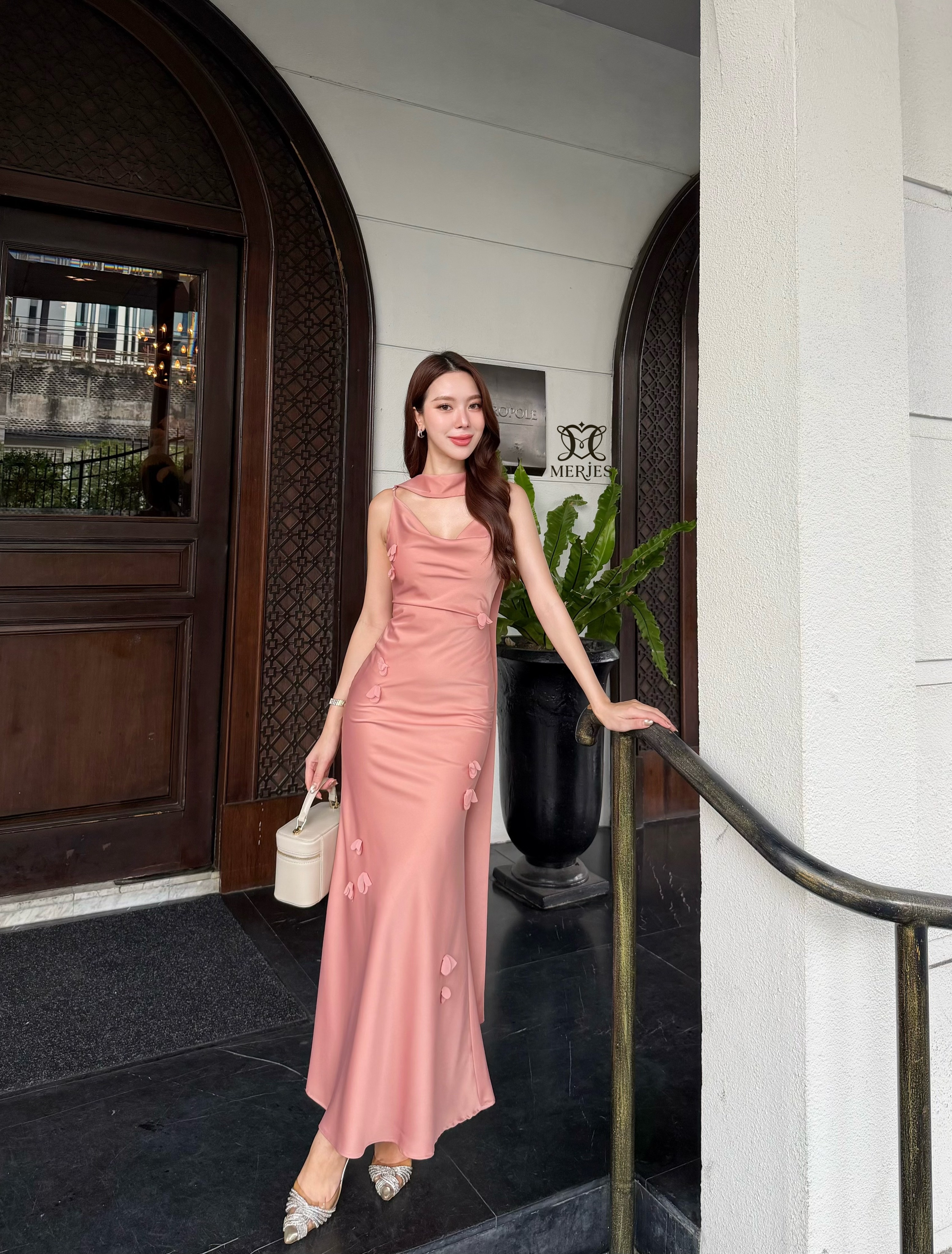 เดรสยาวสีชมพูนู้ดผ้าซาตินสายเดี่ยวเข้ารูปสายสามารถปรับได้แต่งดีเทลด้วยดอกไม้ติดช่วงตัวชุดปลายชุดทรงหางปลาเล็กน้อยเพิ่มความสวยหรูของชุด มาพร้อมผ้าพาดบ่าเพิ่มความเก๋งานมีซับใน