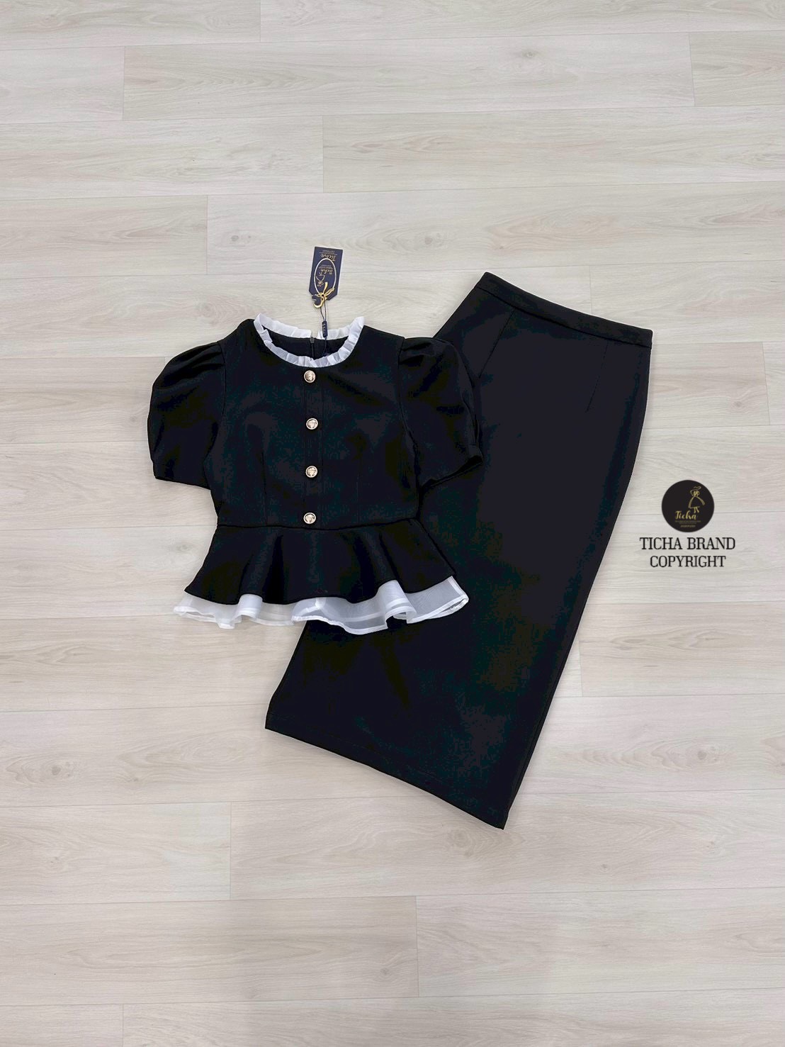 ชุด Set2ชิ้น เสื้อแขนสั้นสีดำทั้งชุด คอกลมแต่งระบาย แต่งระบายผ้าแก้วสีขาวชายเสื้อและแต่งอ่ะไหล่กระดุมทอง (มีซิปหลัง) มาพร้อมกระโปรงทรงสอบดีเทลผ่าหลัง ดีไซน์สวย