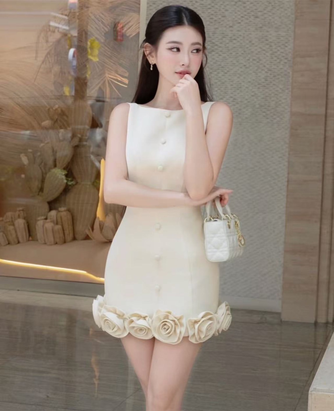 เดรสสีครีมแขนกุดทรงเข้ารูปแต่งดีเทลสุดเก๋ด้วยดอกไม้รอบชุดที่ชายกระโปรงทำให้ชุดดูเก๋น่ารักและแต่งกระดุมแต่งที่ชุดงานเสริมฟองน้ำที่อกมีซับในและซิปด้านหลัง #Miralynstudio#Miralynbrand#miralynชุดออกงาน#เดรสออกงาน#ชุดดินเนอร์